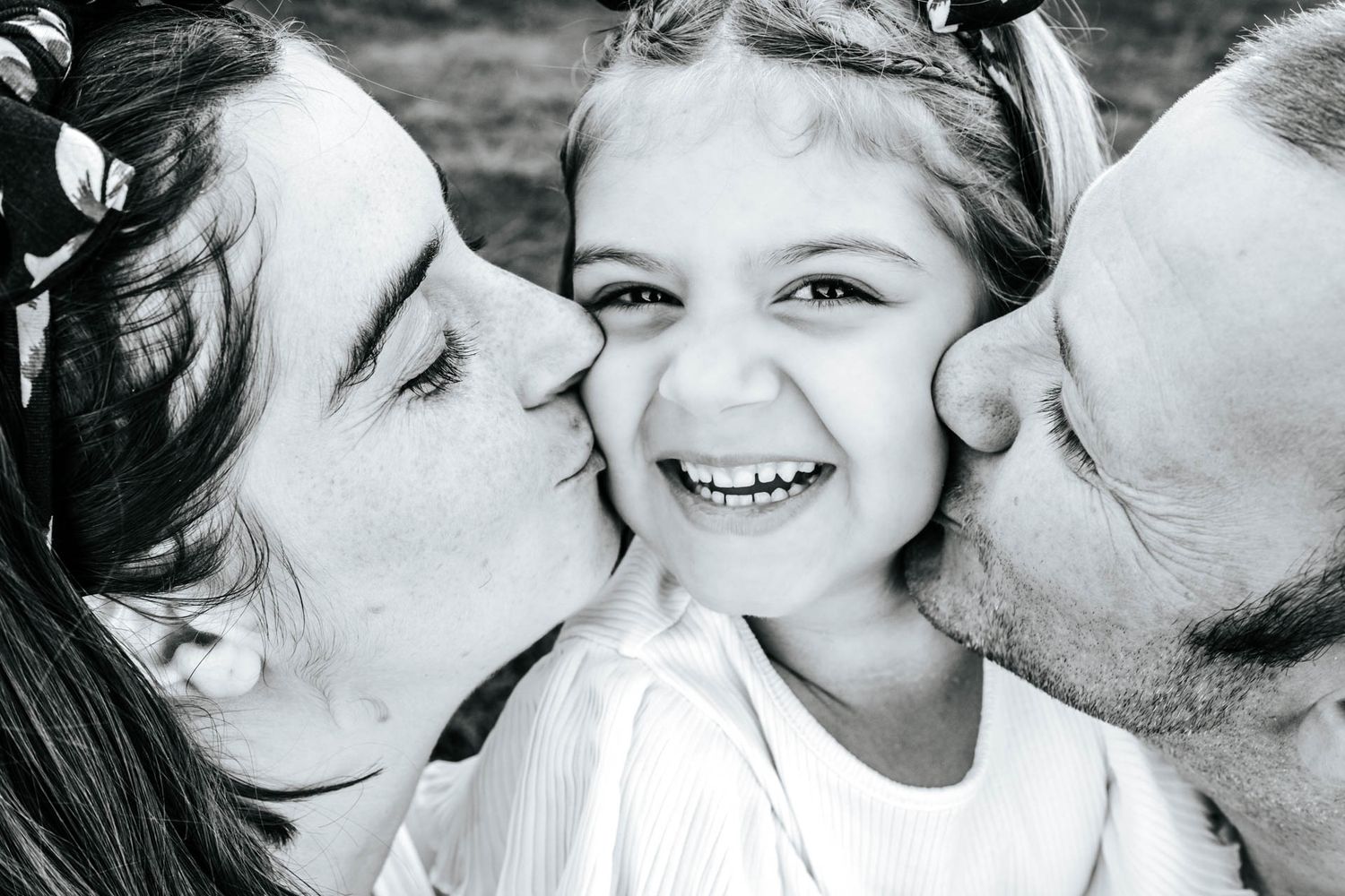 Black and white family portraits showing intimate moments and kisses.