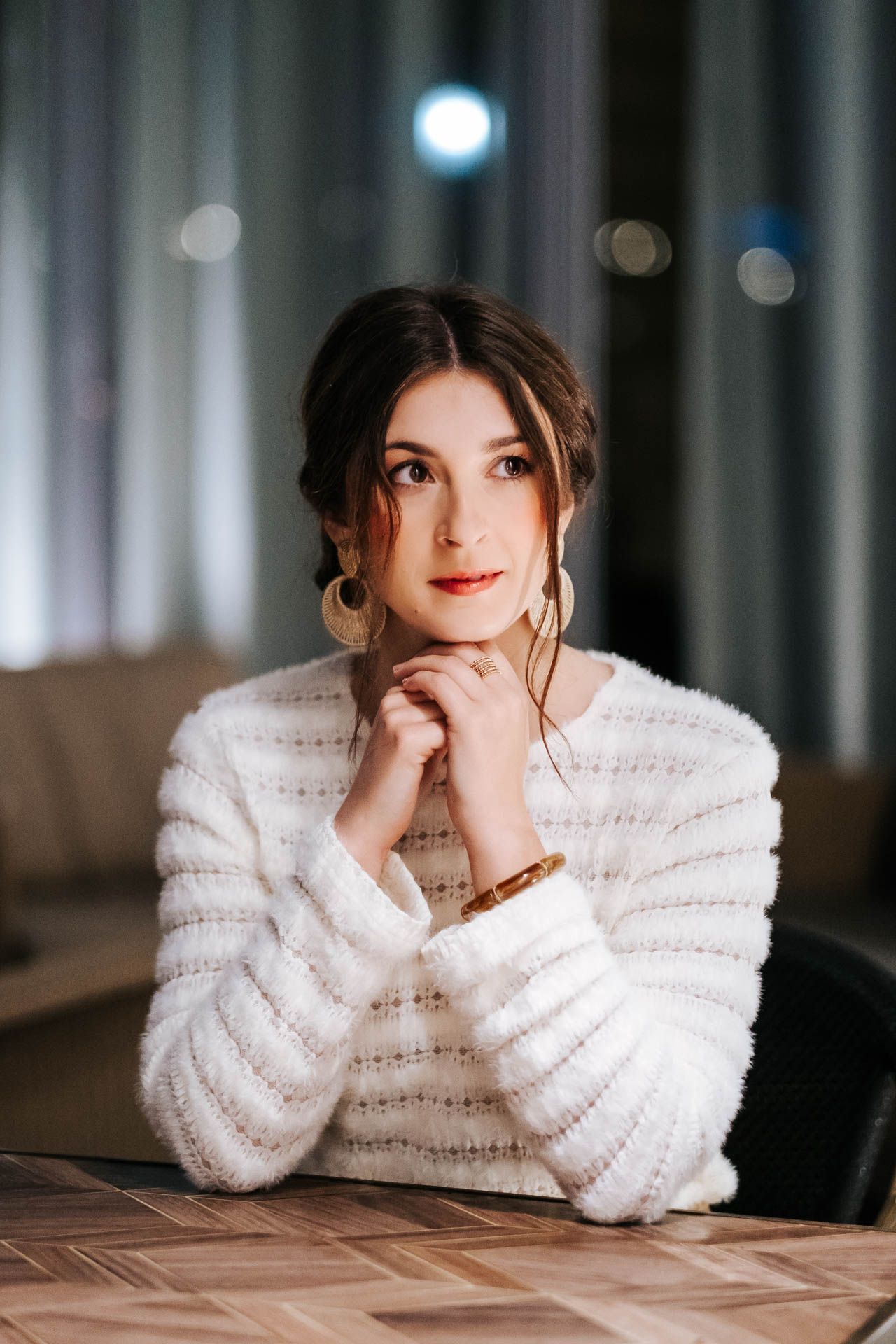 Artistic portrait series in cozy white sweater against dark moody background.