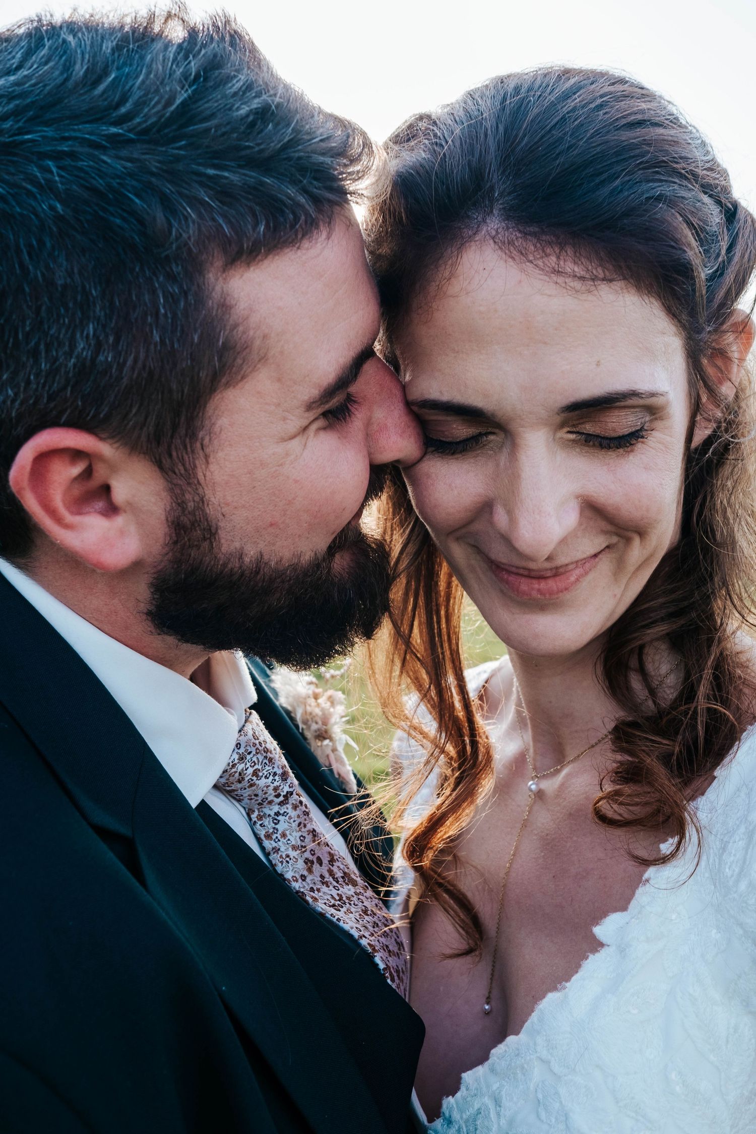 Close up intimate portrait of a couple in wedding attire sharing a tender moment together.