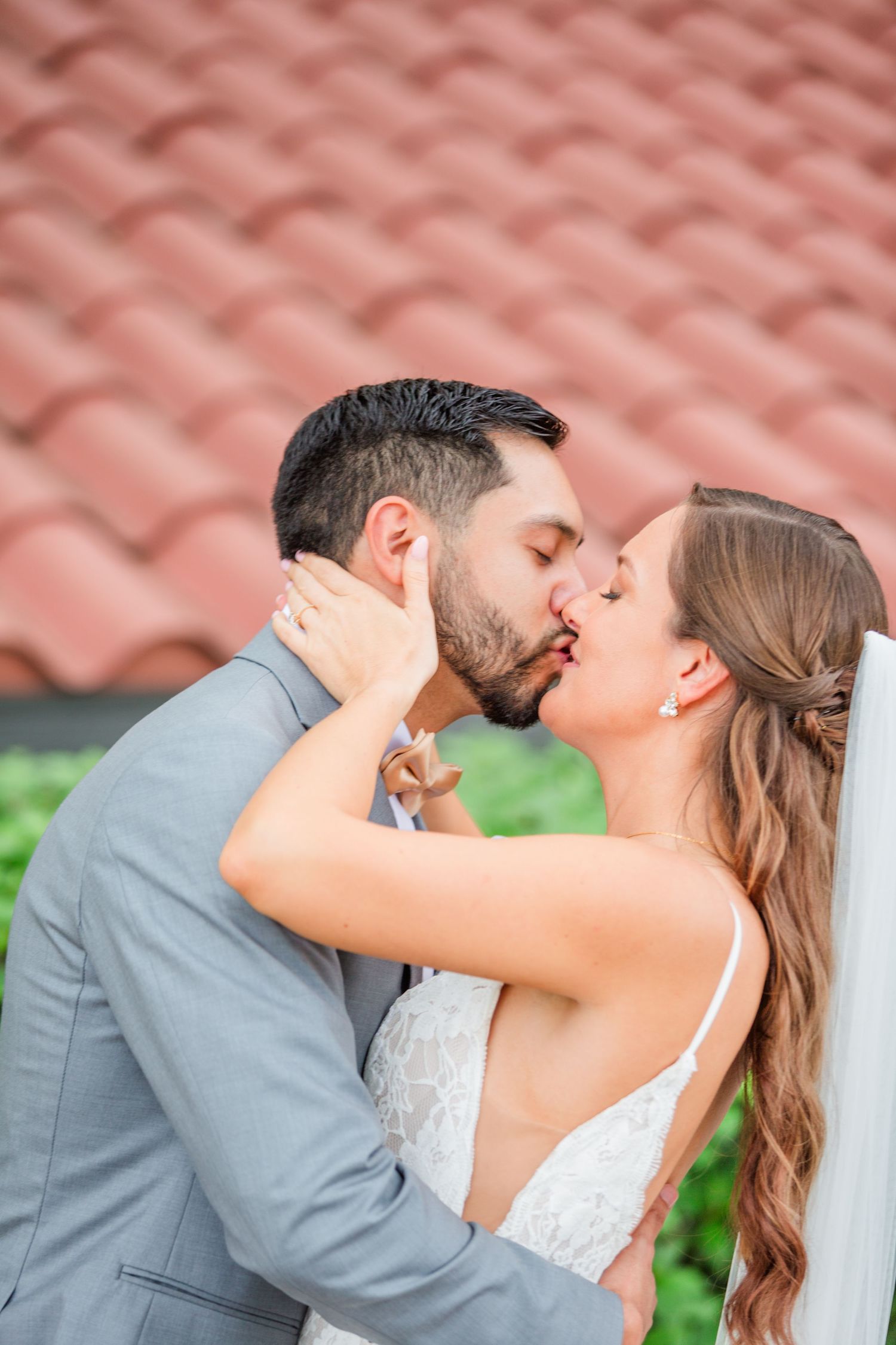 Loving wedding couple embraces during outdoor photo session.