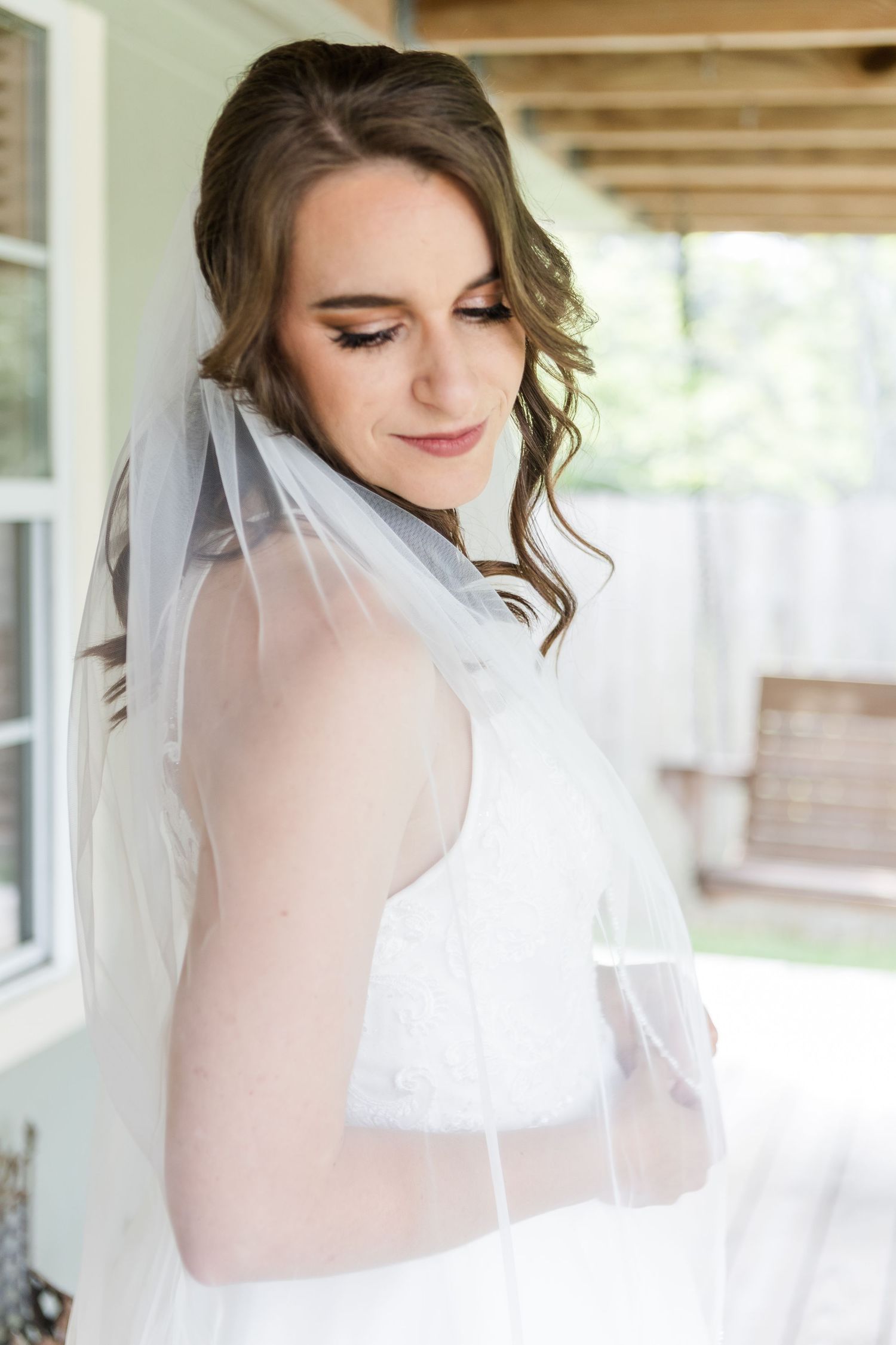 Soft bridal portraits showing a white wedding veil against a light background.