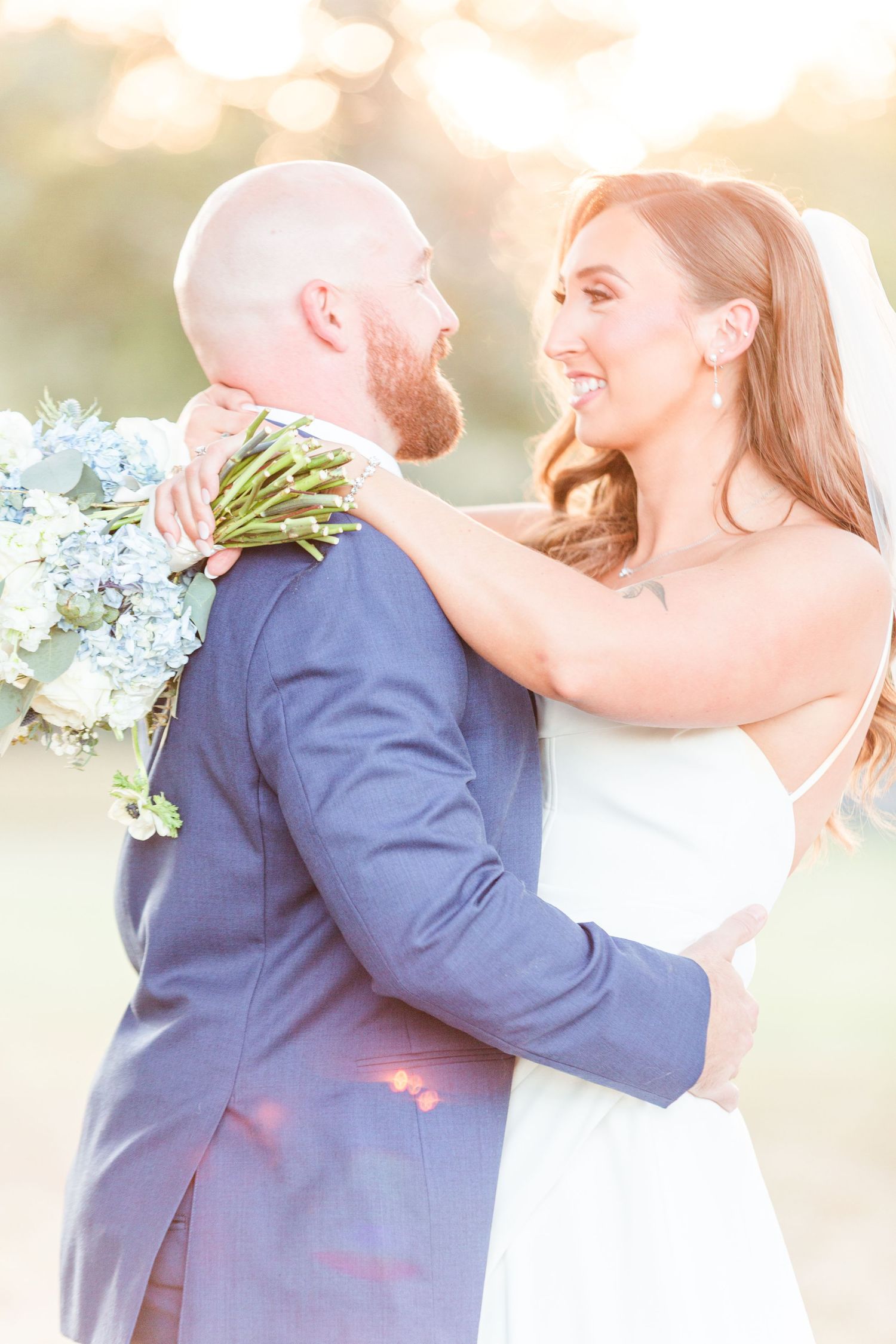 Joyful wedding embrace captured in dreamy outdoor lighting.