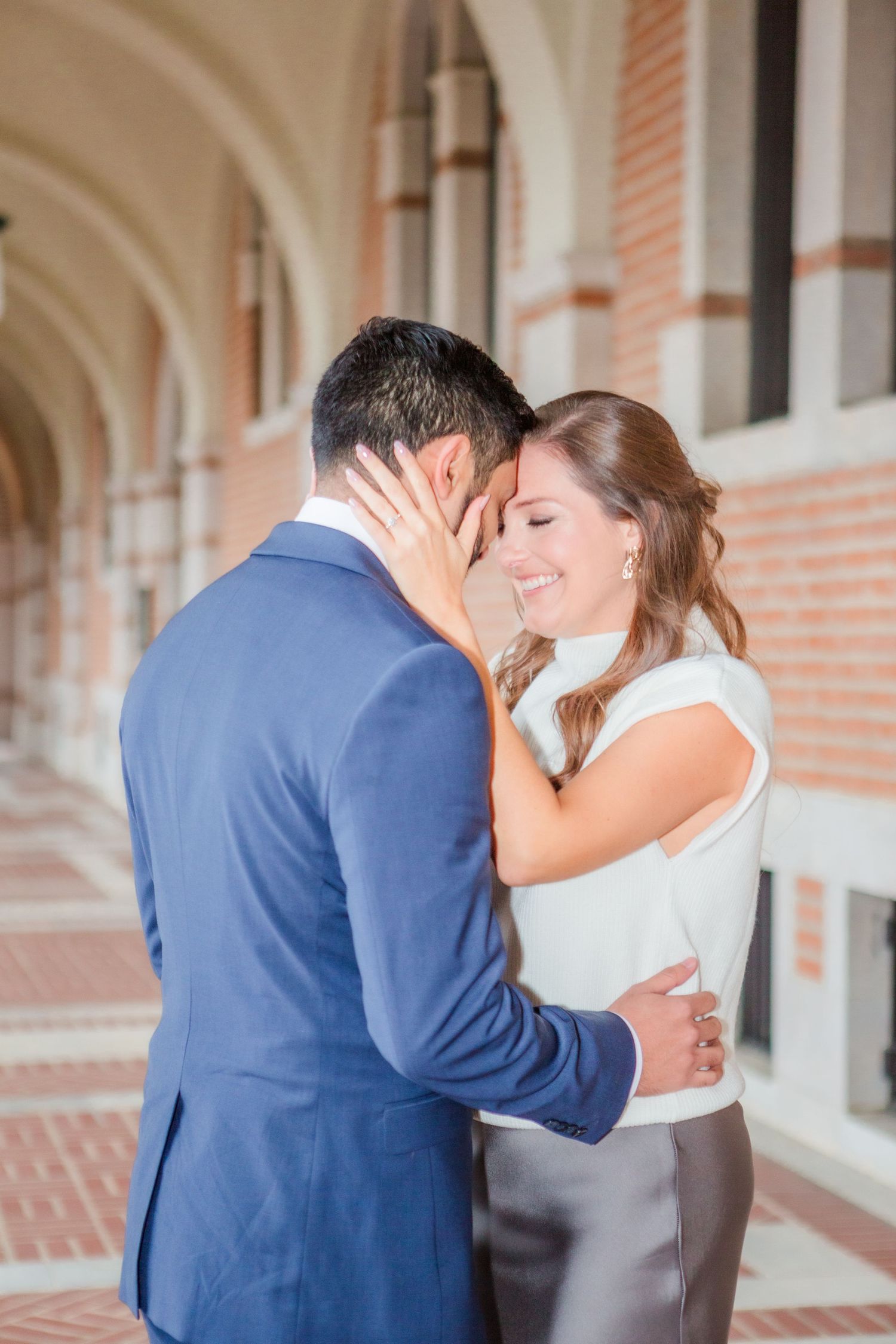 Intimate moment shared between couple in ornate hallway.