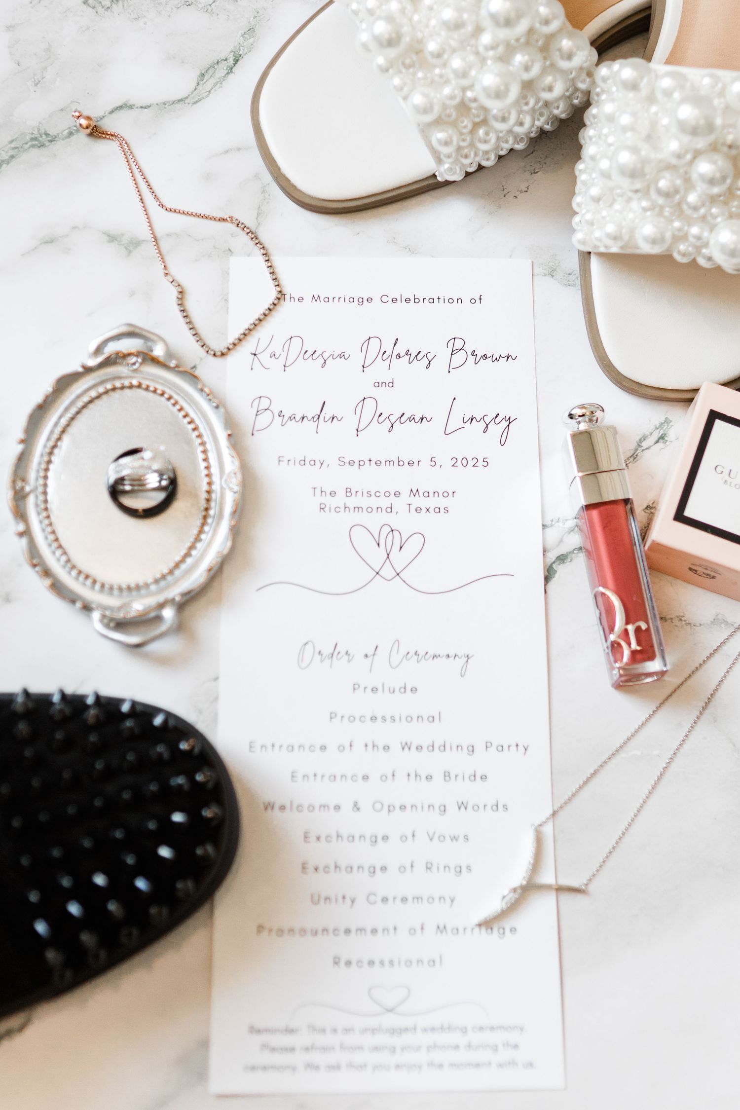 Wedding invitation suite with pearl accessories and rose gold details on white background.