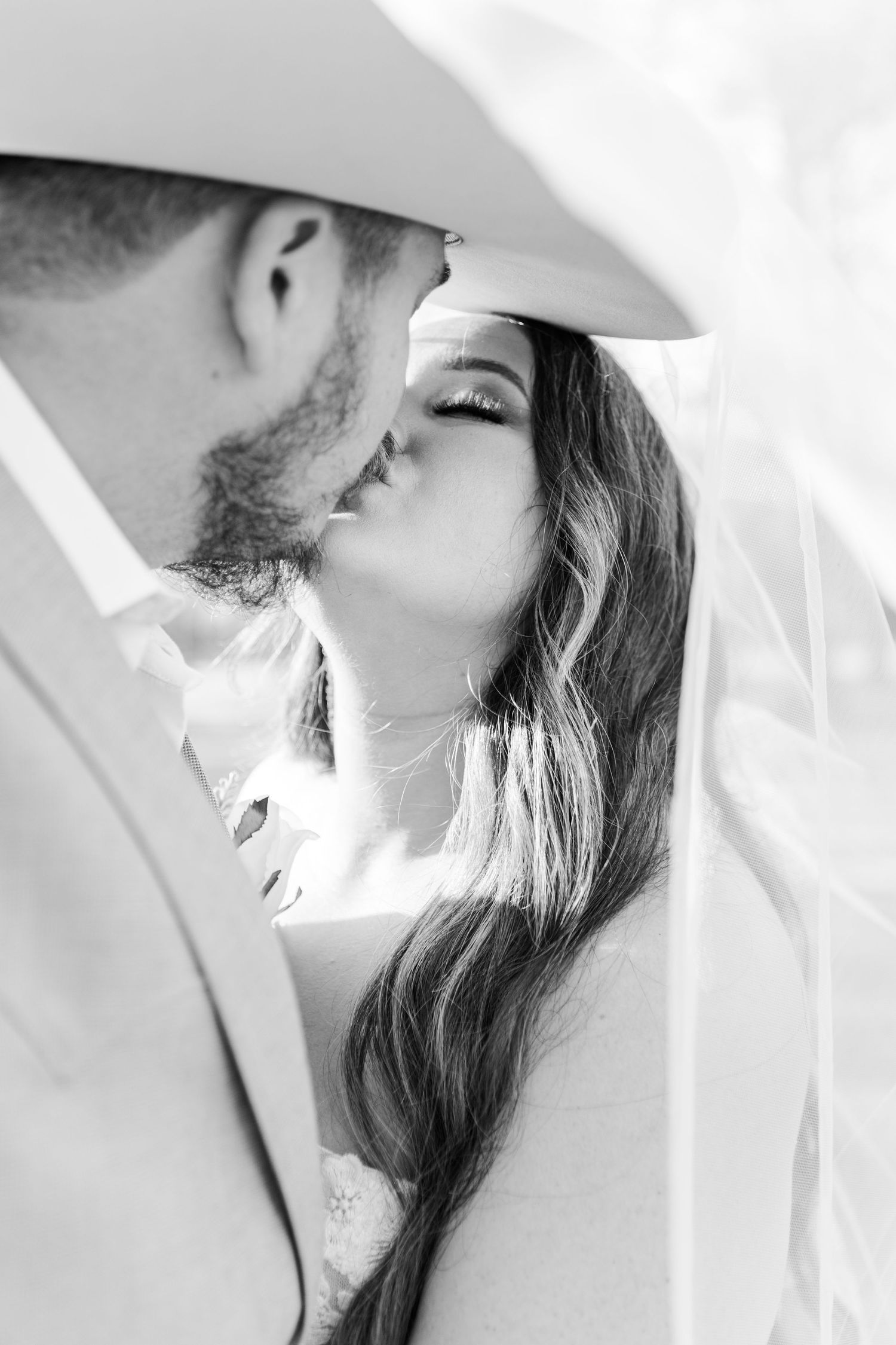 Romantic black and white portrait series showing a couple sharing intimate moments in elegant wedding attire.
