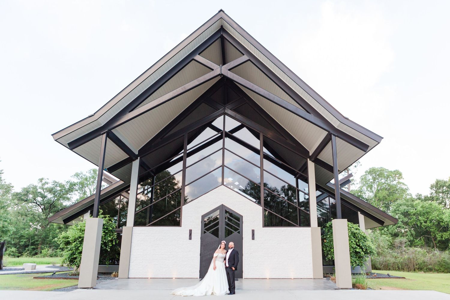 Modern white chapel building with angular architecture and peaked roof shown from different angles.