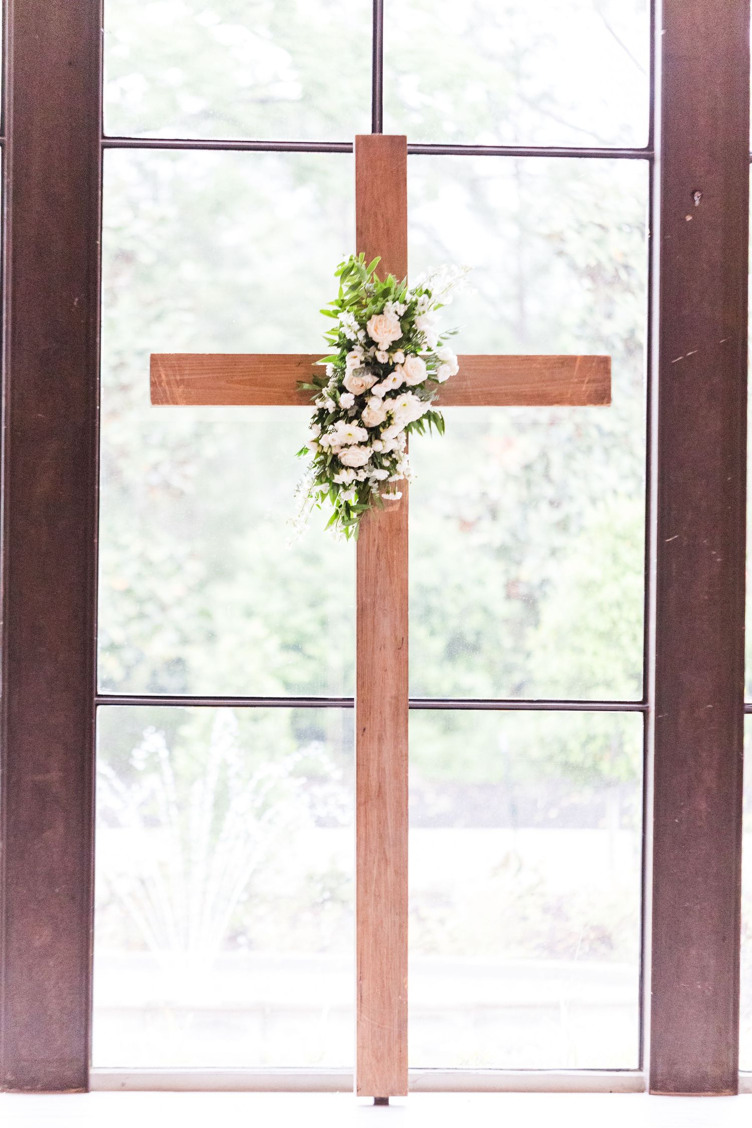 Large windows and wooden beams create a bright, airy wedding venue interior with natural light.