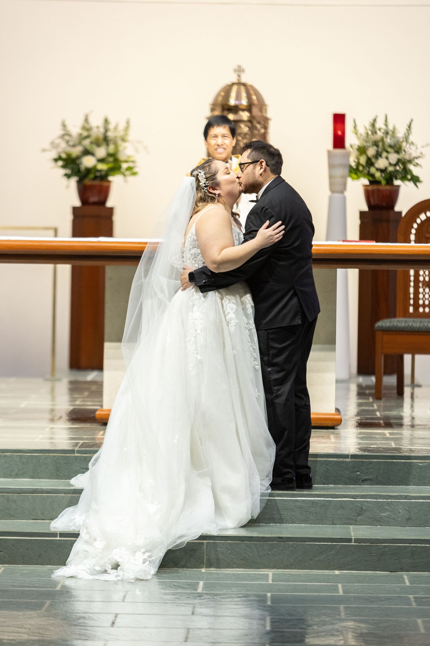 Couple sharing their first kiss at the altar during their wedding ceremony.