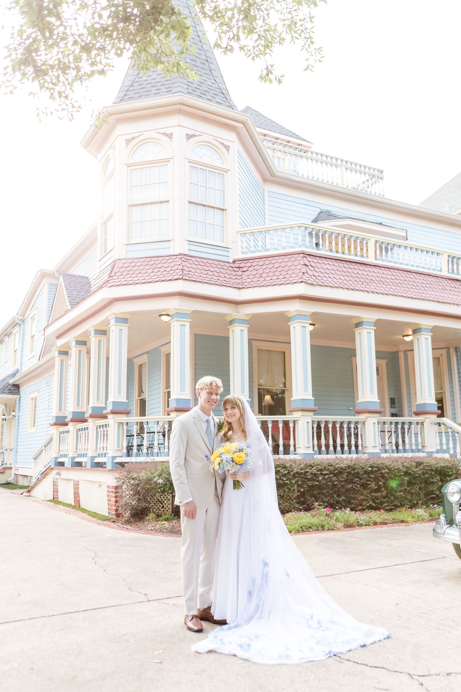 Wedding photography at Victorian mansion with white wraparound porch and ornate details.