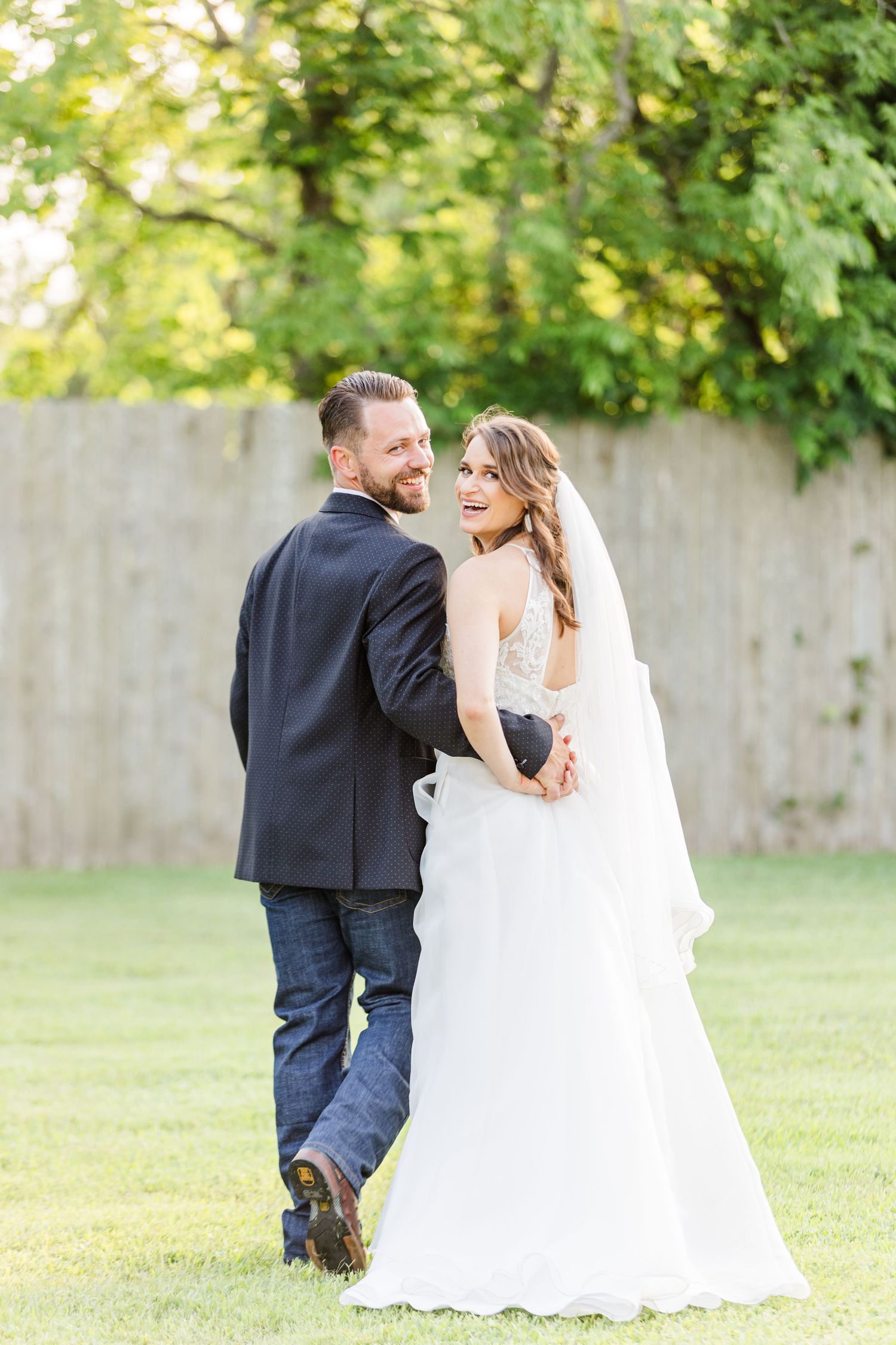 Candid wedding photos in sunlit garden with white dress and dark suit.