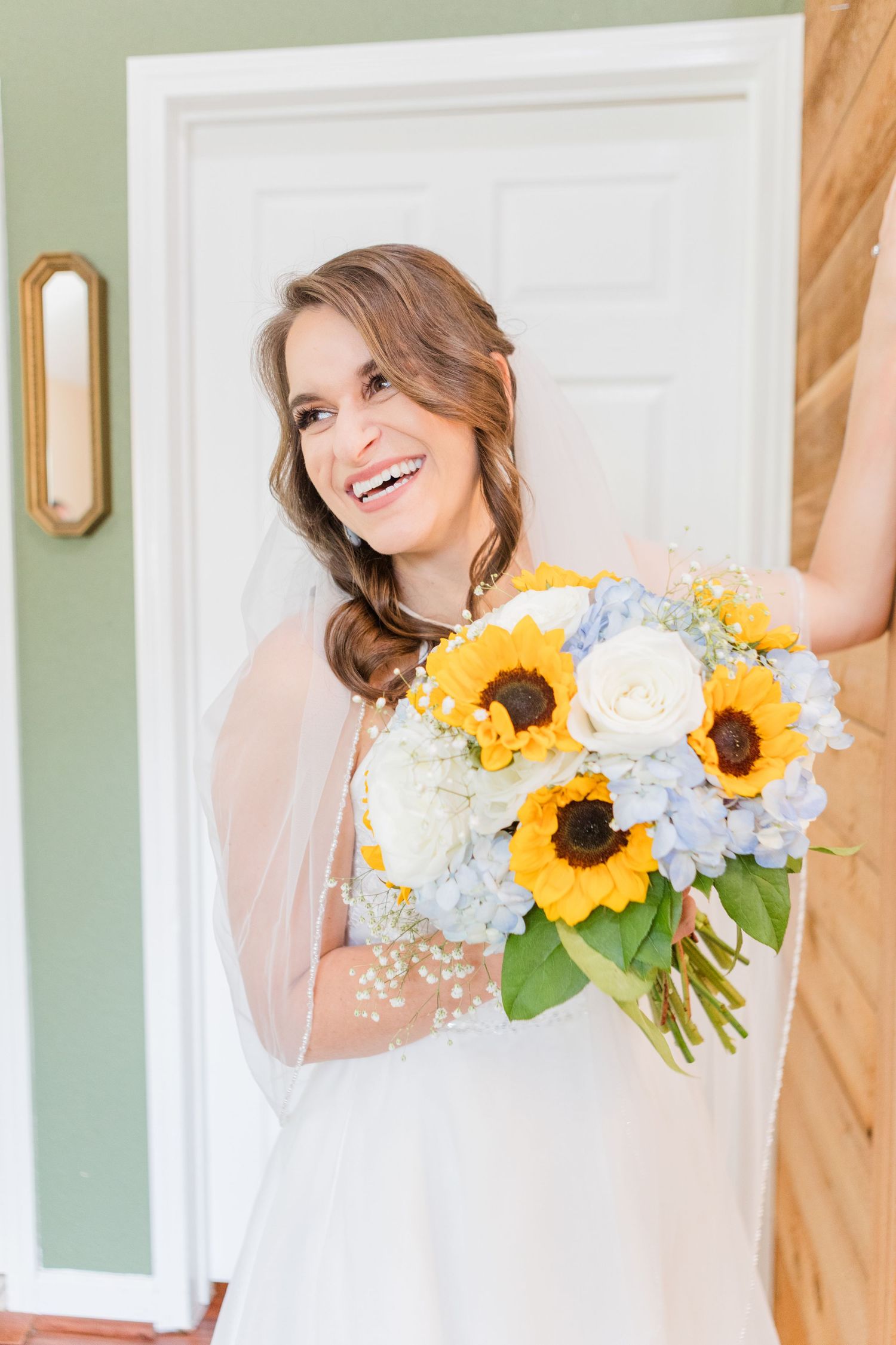Bridal portraits featuring sunflower and hydrangea bouquet against white doors.
