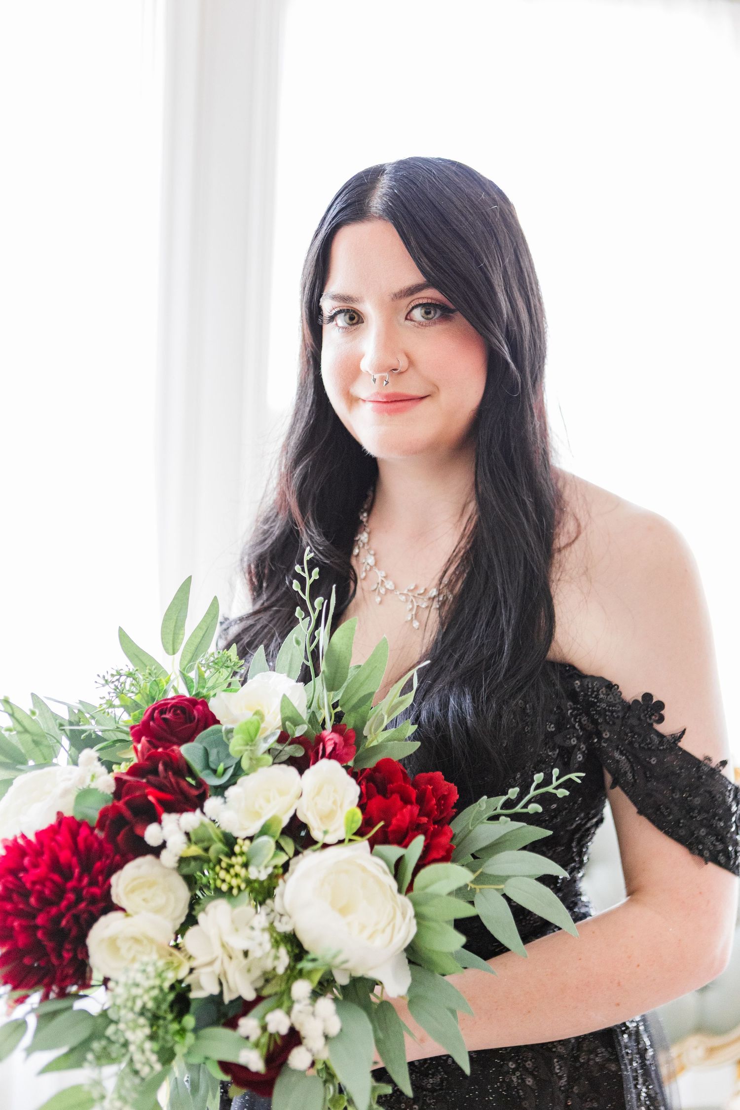 Portrait with burgundy and white flower bouquet against bright white background.