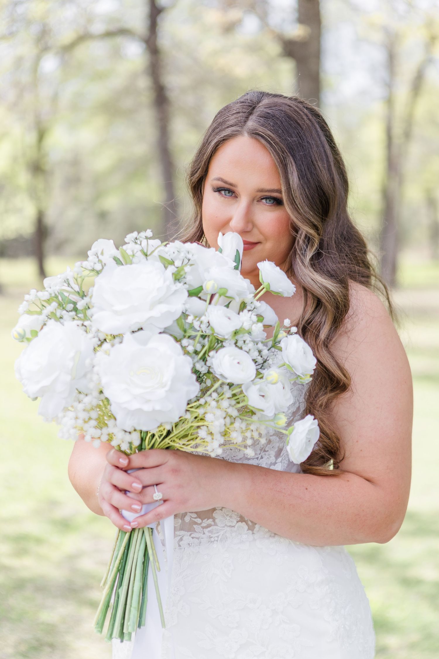 Beautiful bridal portrait with white rose bouquet in an outdoor garden setting.
