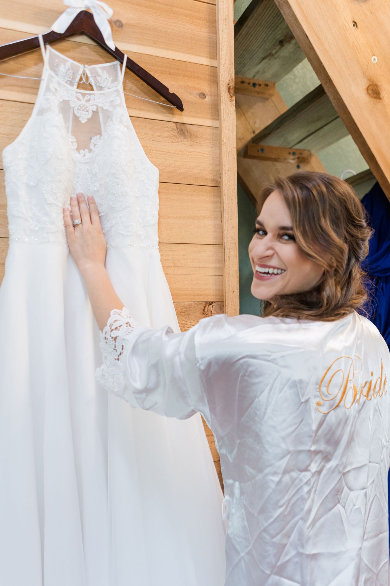 Behind the scenes getting ready shot with white wedding dress hanging.