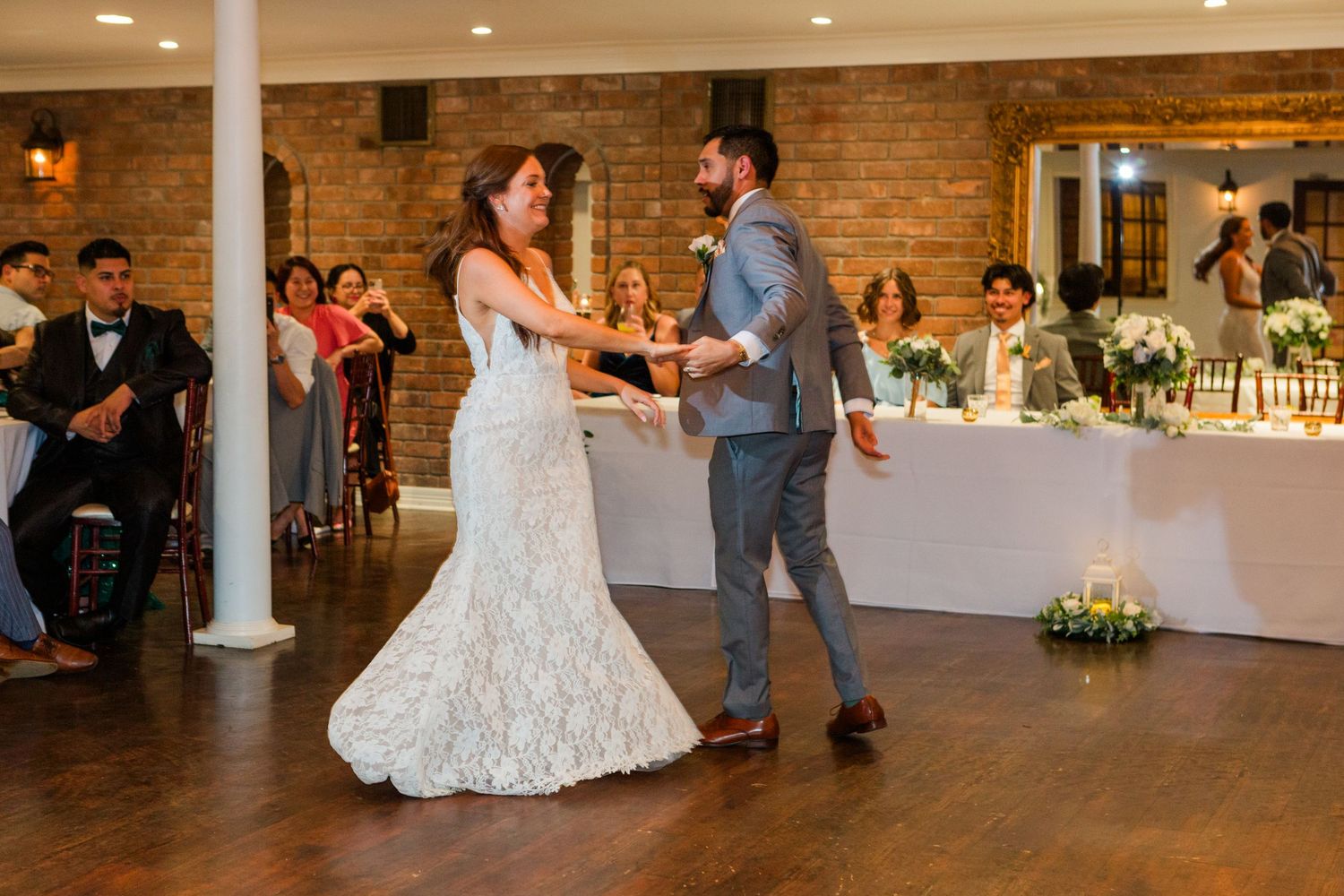 Wedding reception dance floor sequence in a rustic brick venue with white columns.
