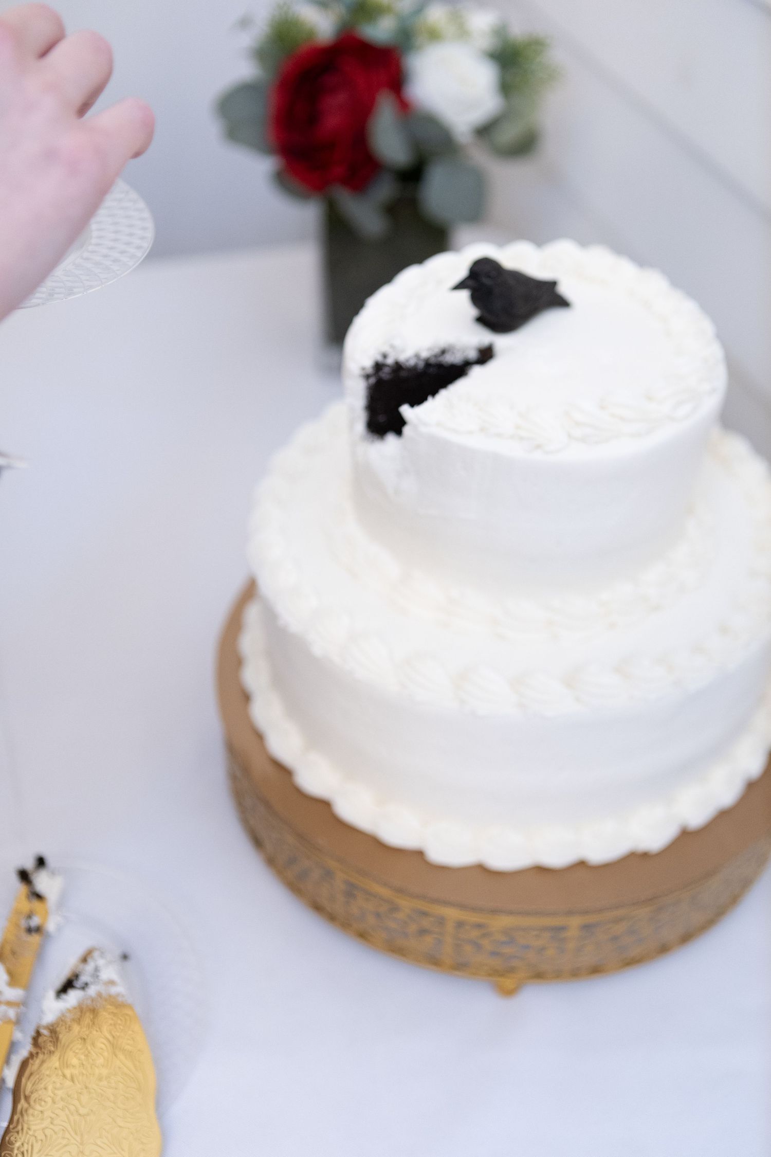 Close-up sequence of a white frosted cake on a gold stand with red floral decorations.