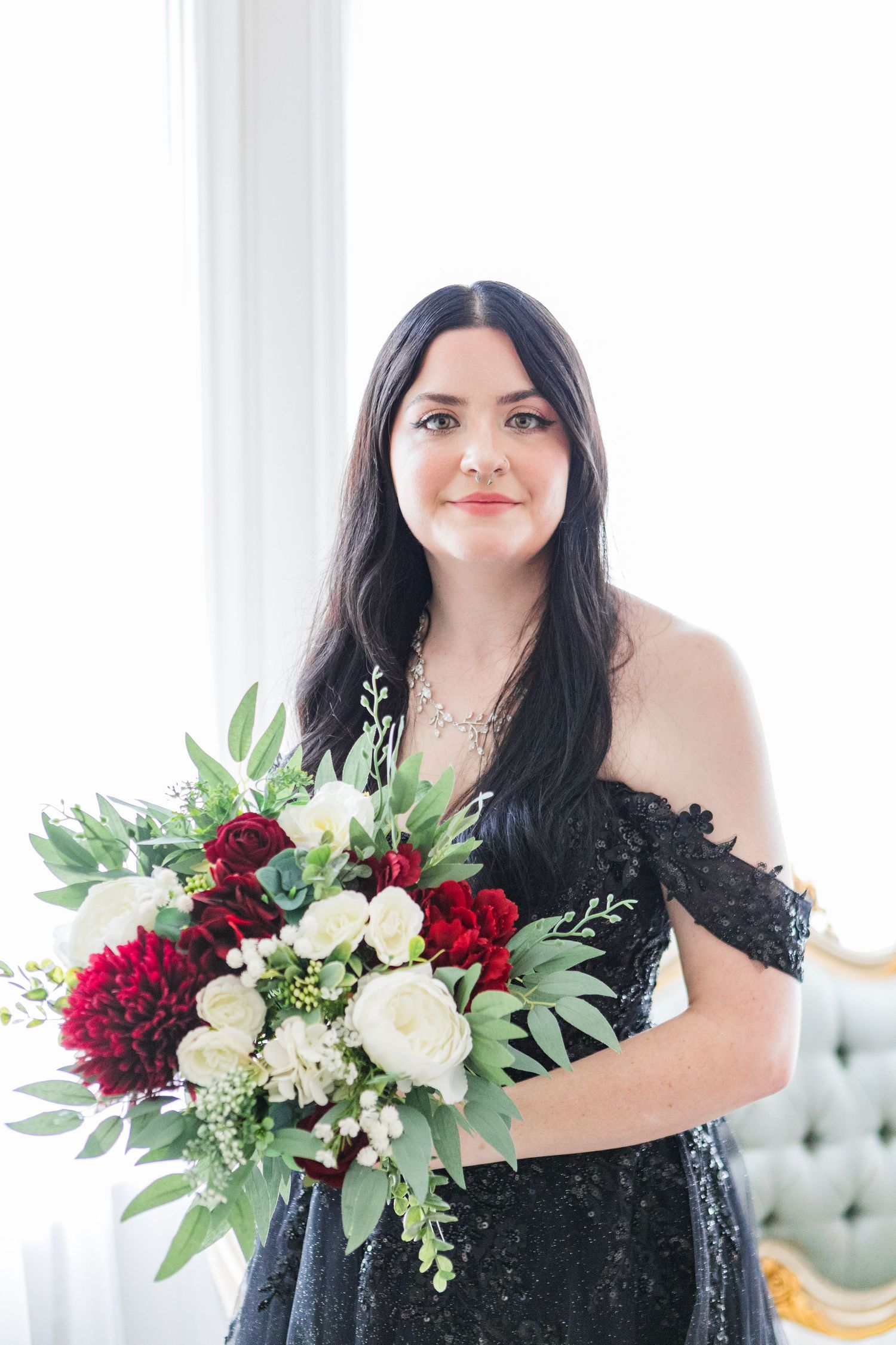 Portrait session featuring elegant black dress and burgundy floral bouquet.