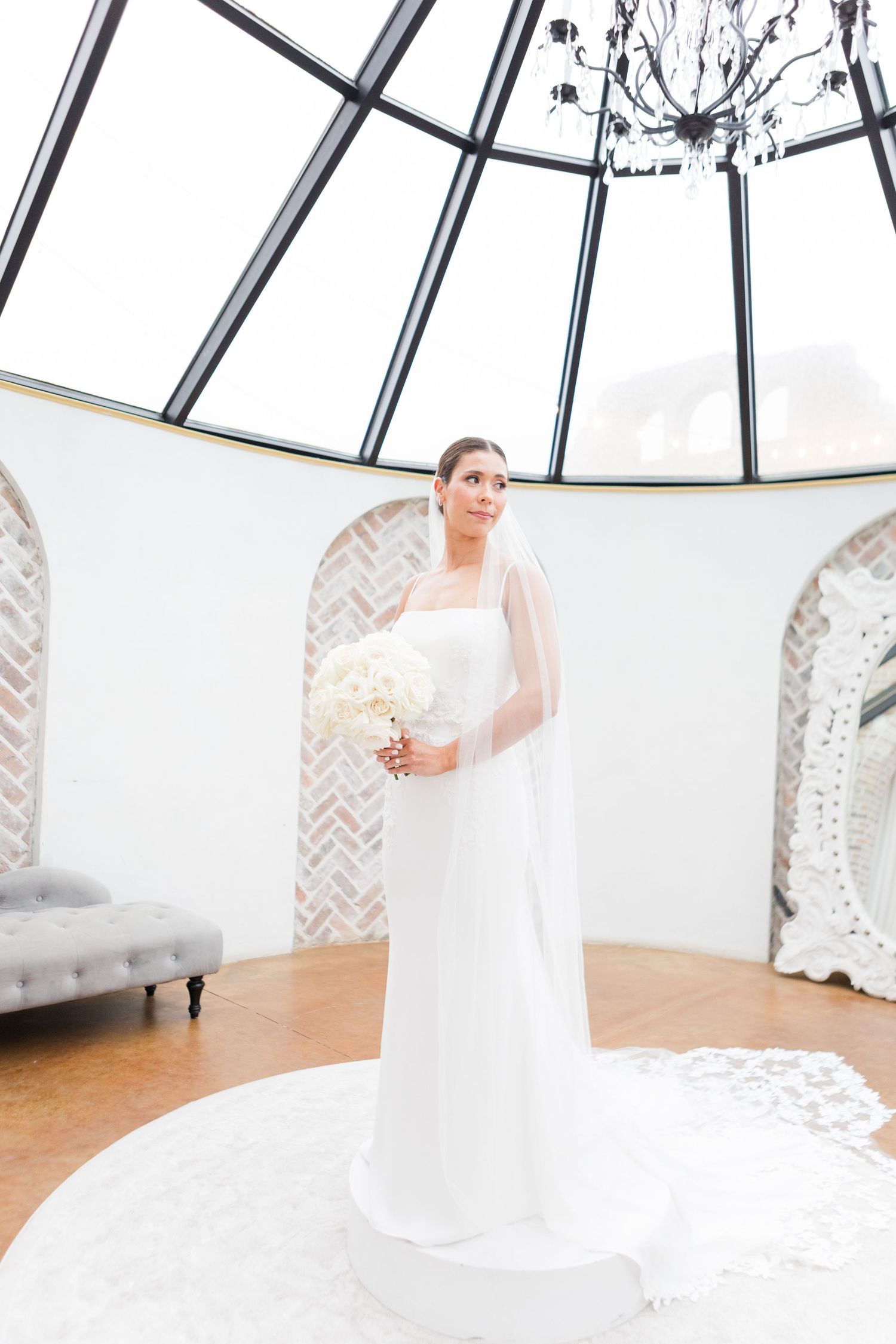 A close-up view of a white bridal bouquet made of fresh roses held against an elegant background.
