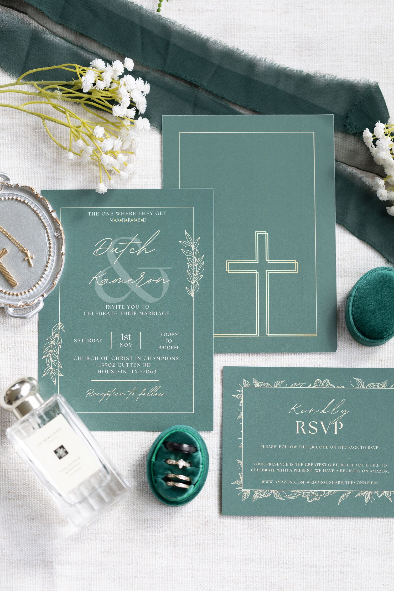 Elegant sage green wedding invitation suite with white floral details and cross design displayed with ornate decorations.