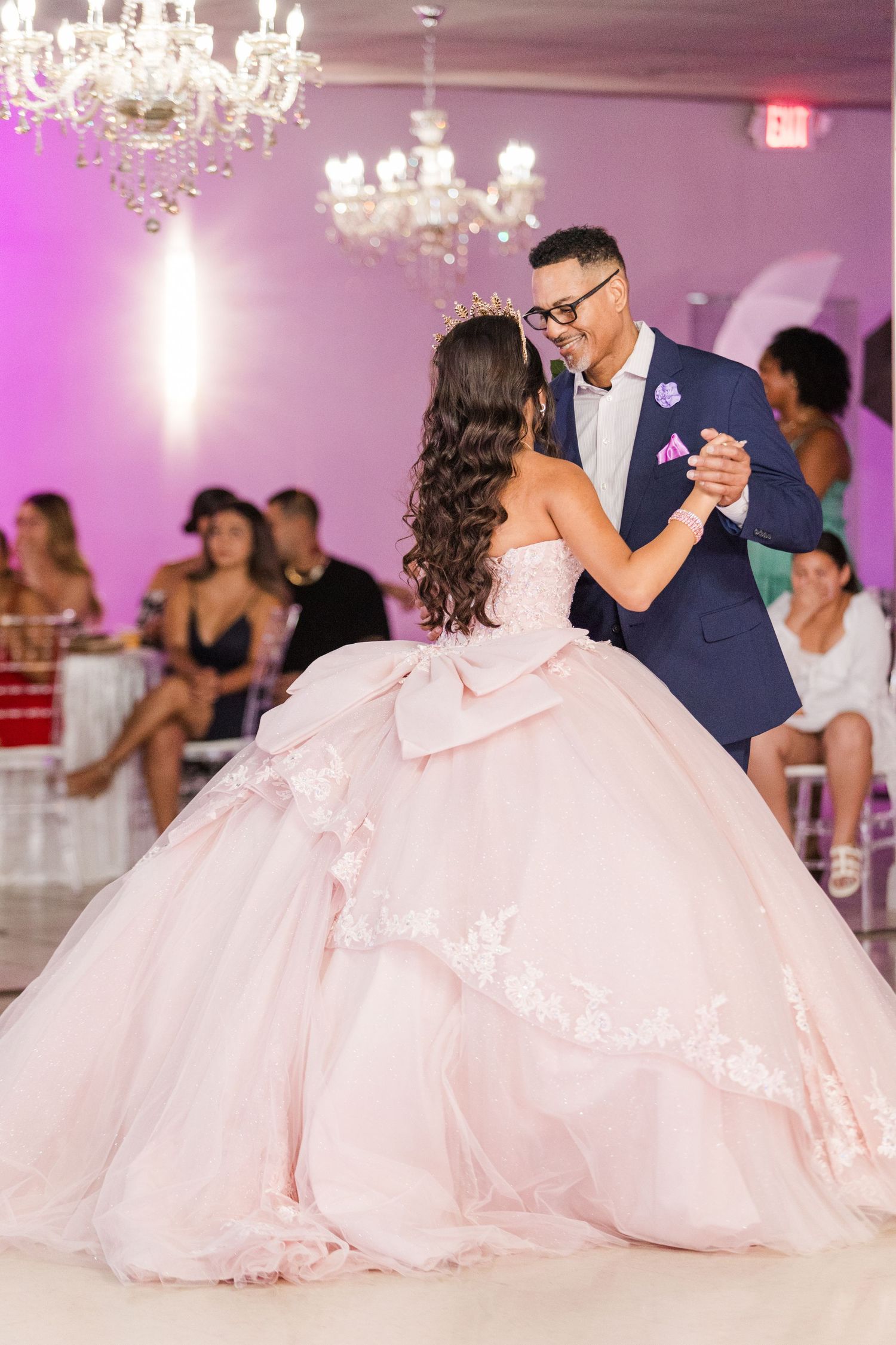 Elegant ballroom dance moment captured under crystal chandeliers during a formal celebration.