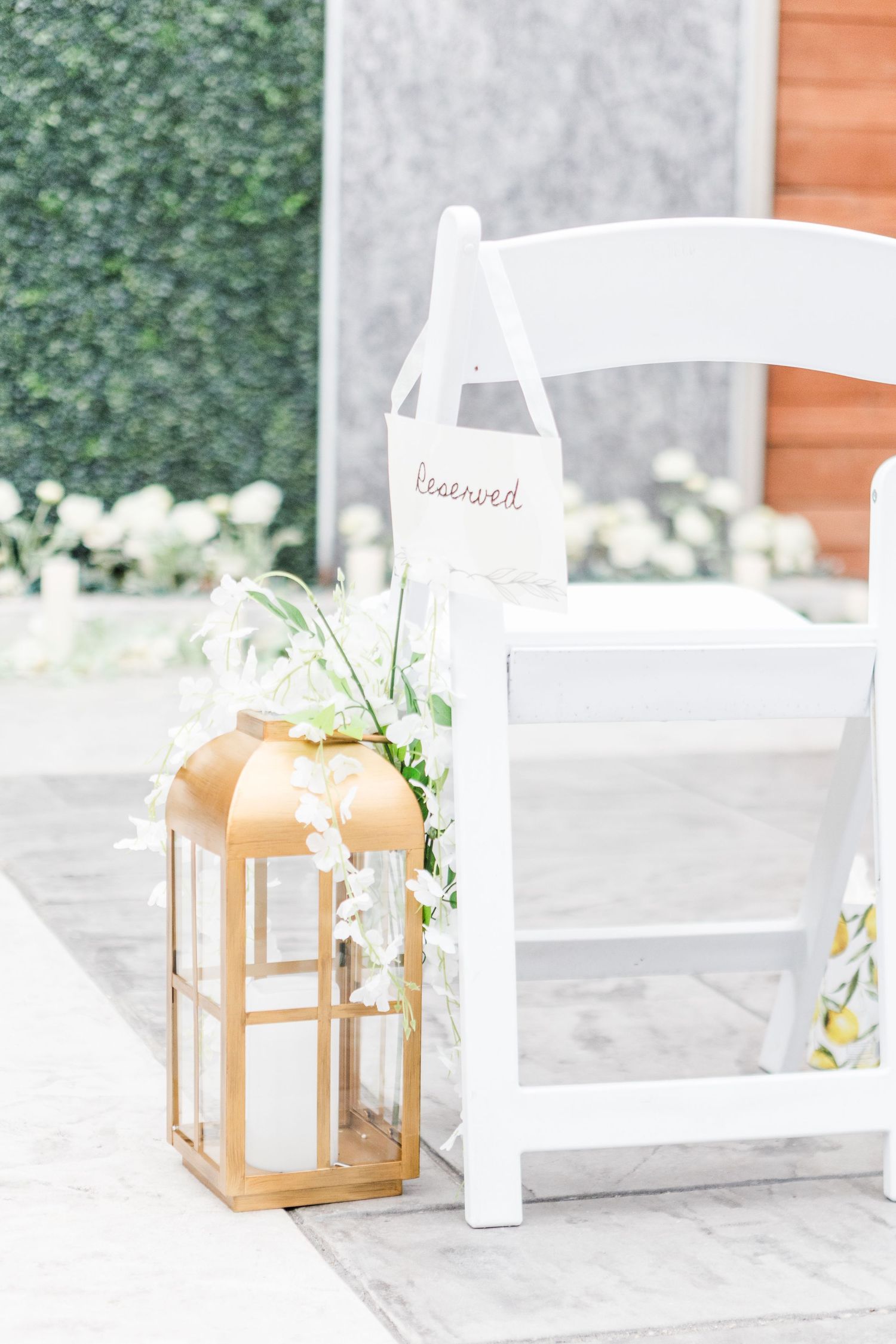 Rustic wooden lanterns and candles arranged on a white surface with greenery.