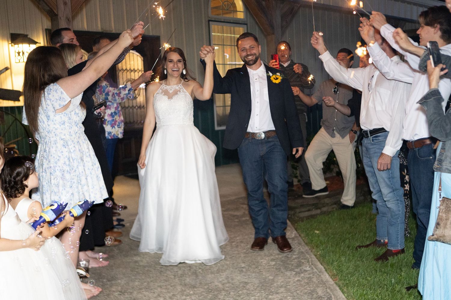 Wedding celebration at night with sparklers creating magical light trails among guests.
