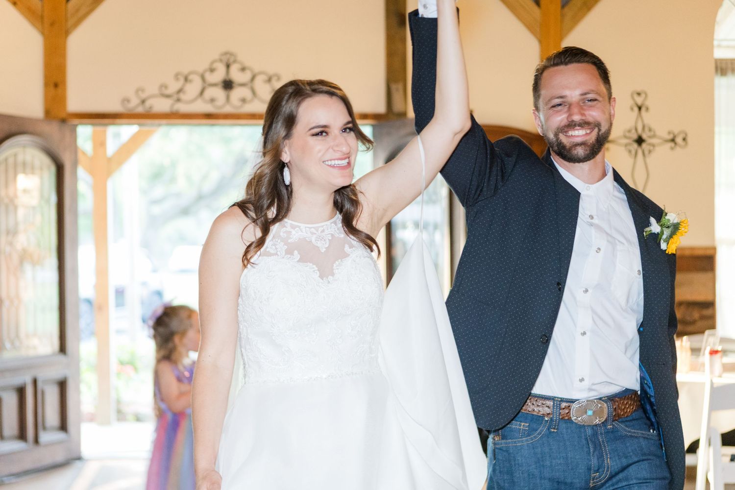 A joyful dance scene in a rustic barn venue with wooden beams and natural light.