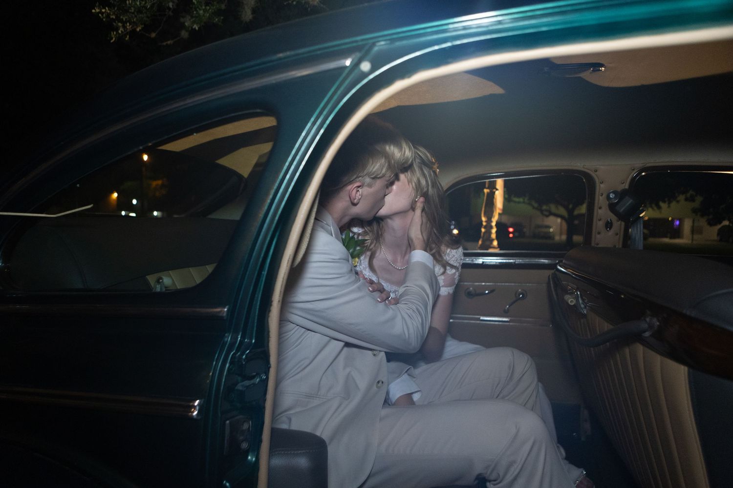 Newlyweds getting into their getaway car after their wedding celebration.