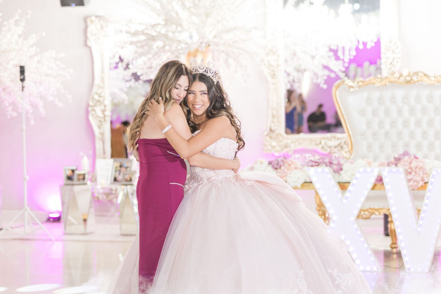 Elegant celebration venue decorated in pink and white with sophisticated lighting and decor.