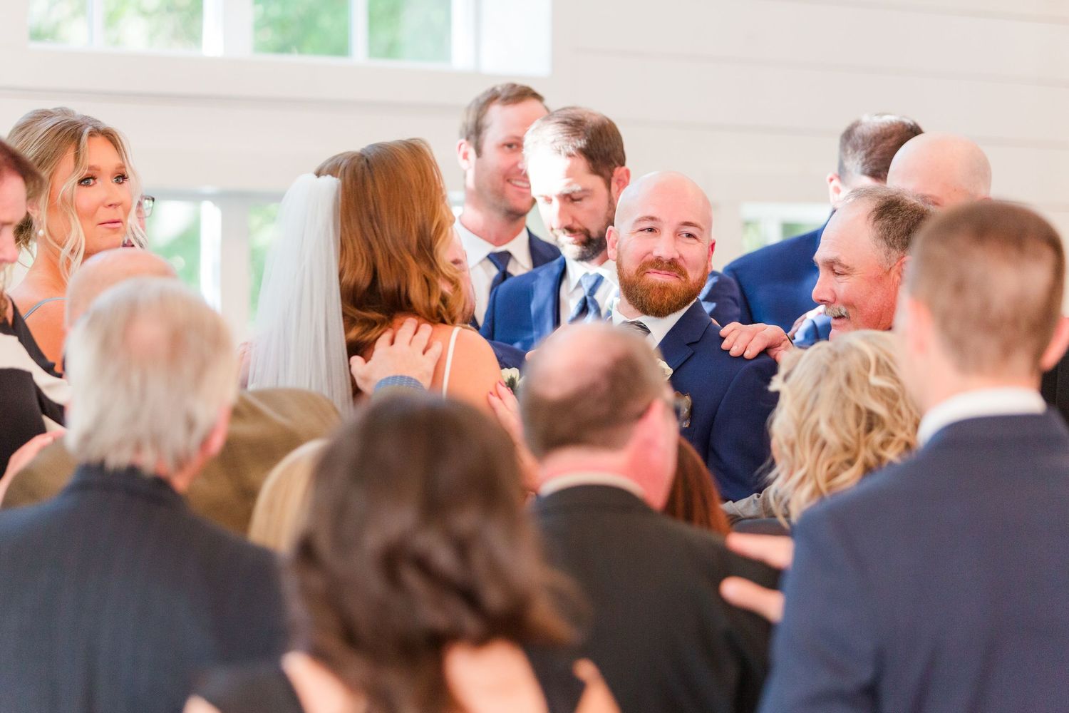 Guests gathered at an elegant wedding ceremony in a light-filled indoor venue.