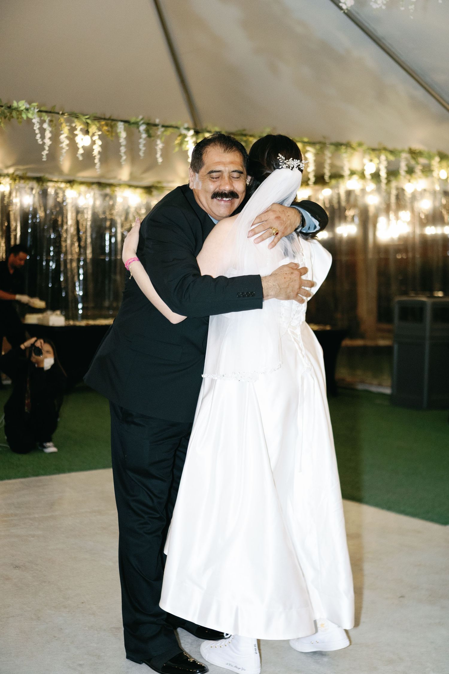 Wedding celebration under twinkling lights with joyful dance moments.