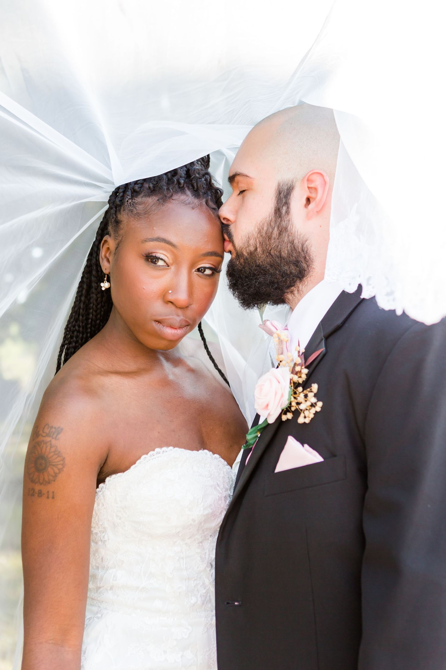 Romantic wedding portraits under white veil showing intimate moments between newlyweds.