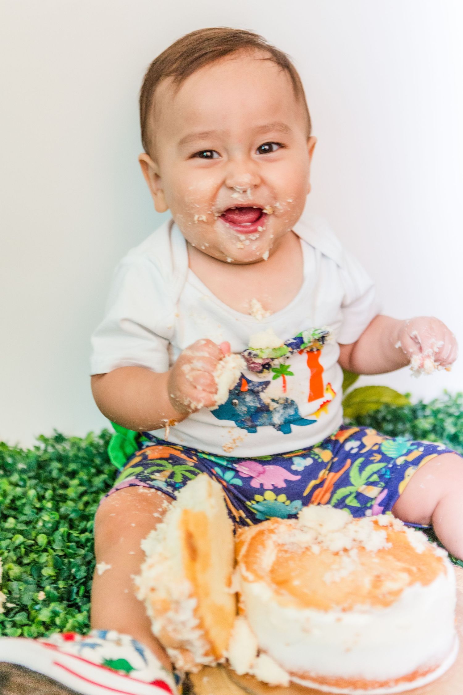 Close-up of messy cake smash party with frosting and decorative elements.