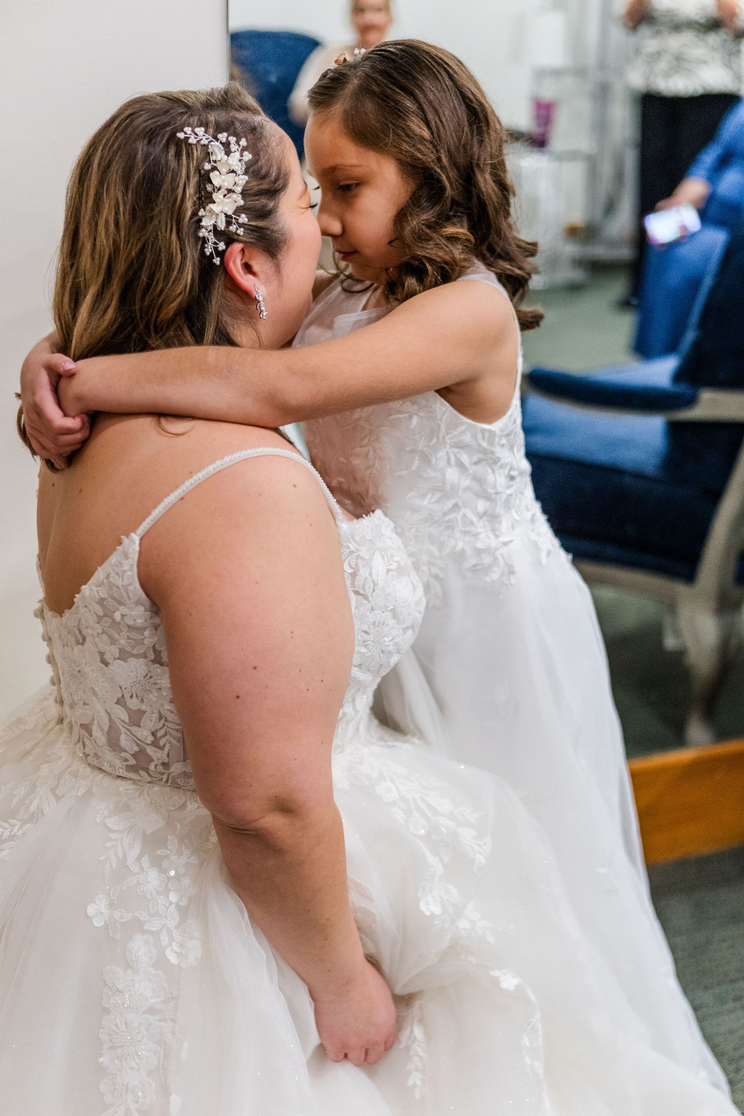 Two brides in white wedding dresses share an intimate embrace during their wedding celebration.