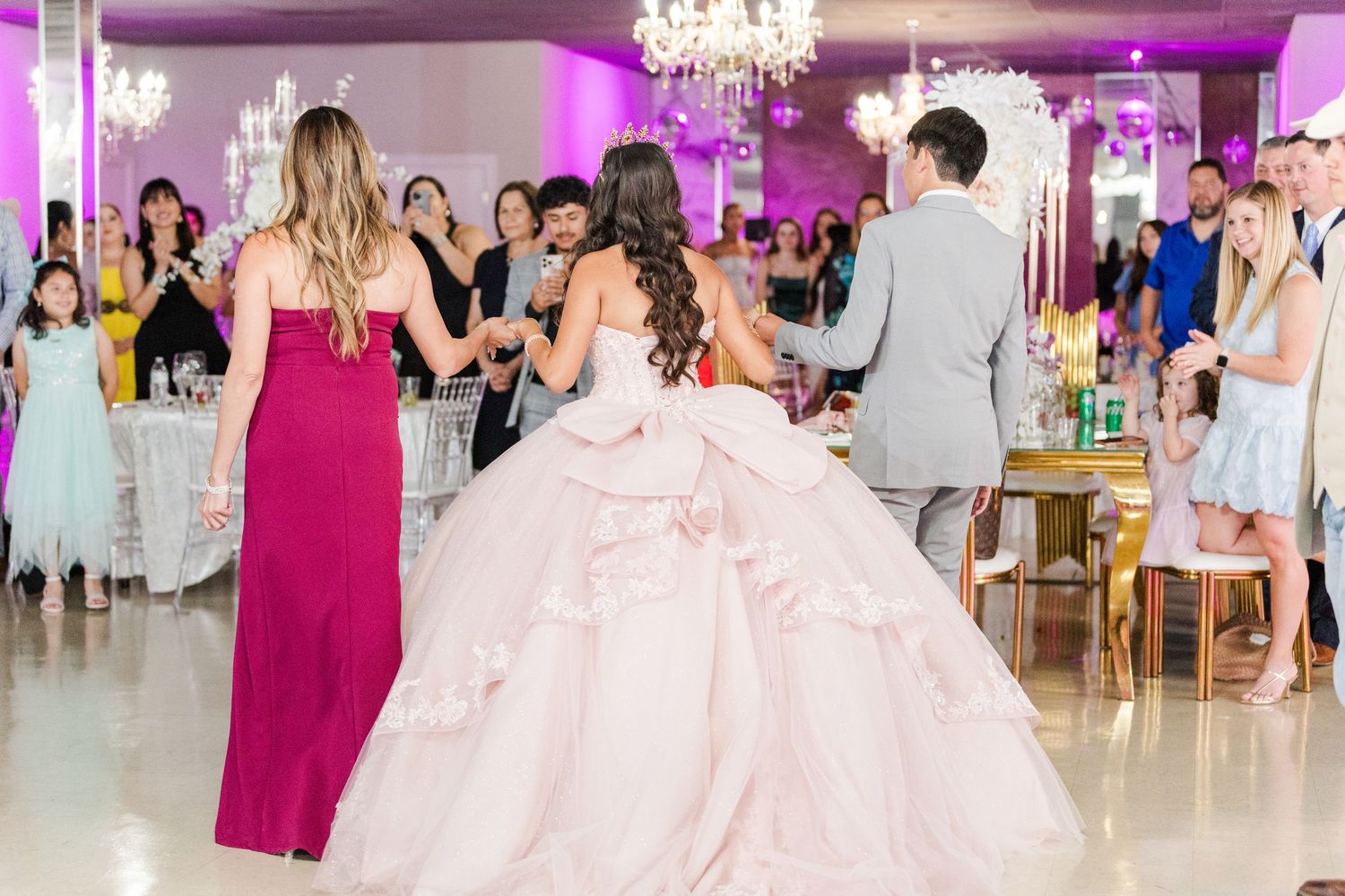Celebration dance scene in an elegant ballroom with pink and purple lighting.