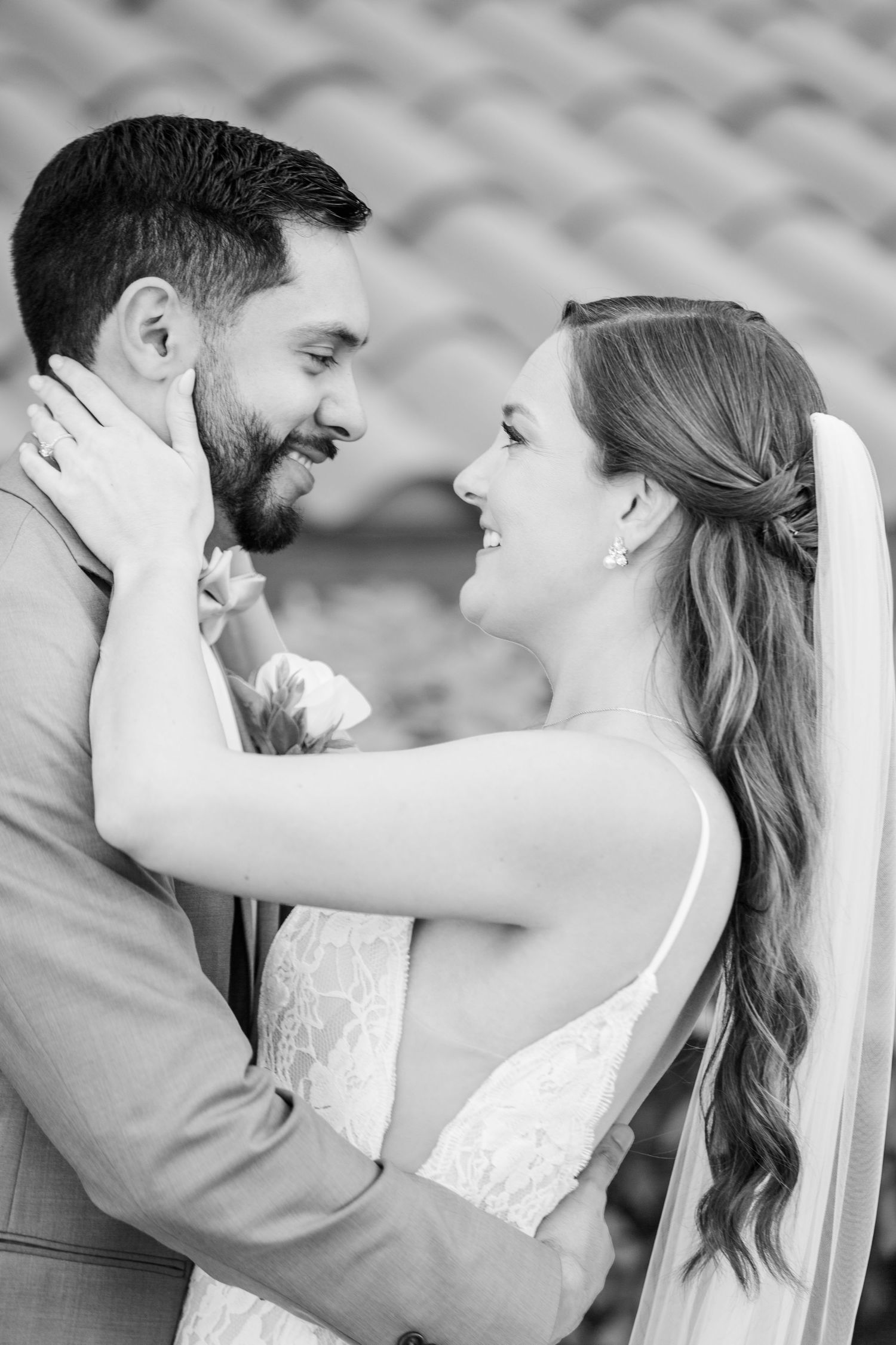 Black and white romantic wedding moment captured against textured background.
