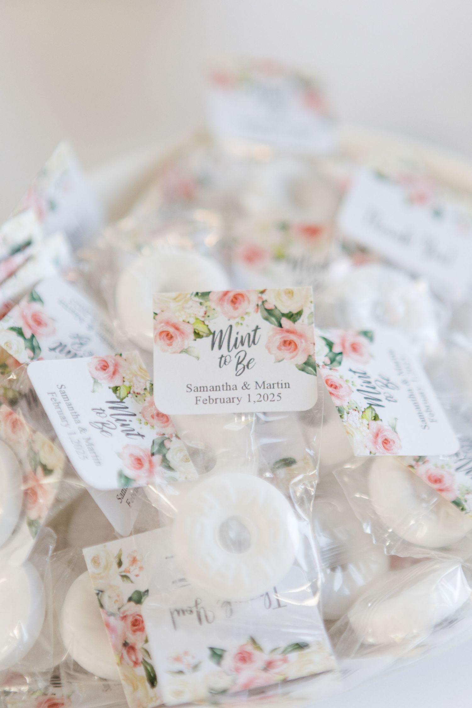 Wedding favor bags with floral design labels and mints inside.