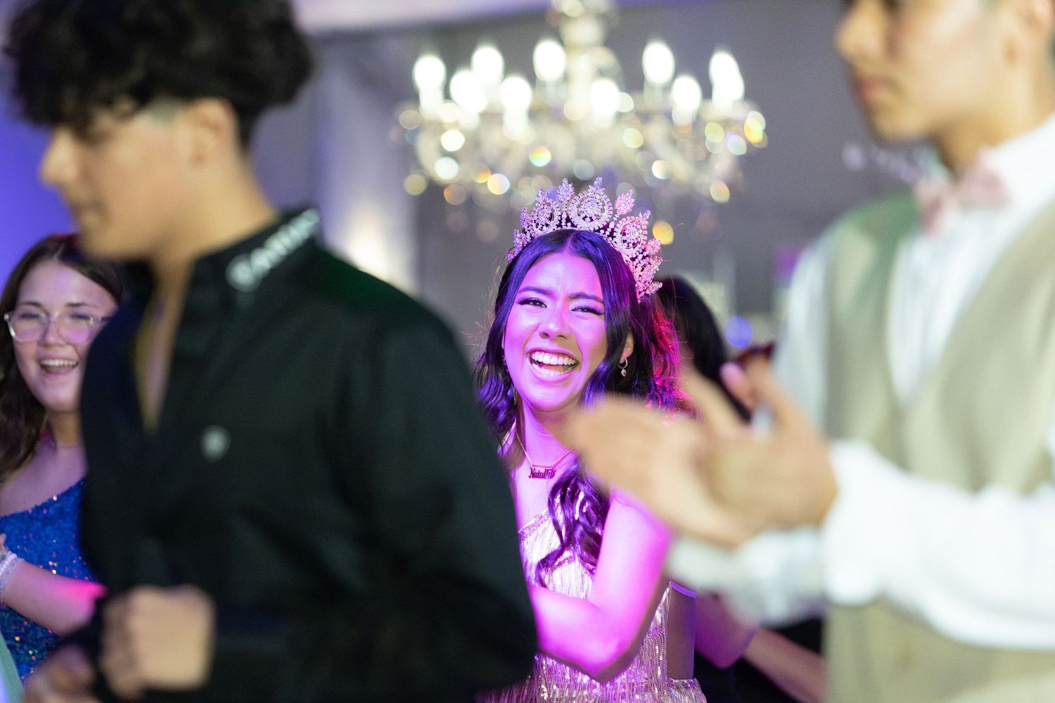 Celebration at an indoor party venue with vivid purple lighting and enthusiastic dancers.