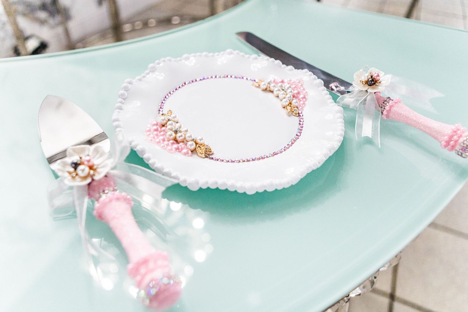 Delicate party accessories in mint and pink tones arranged on light background.