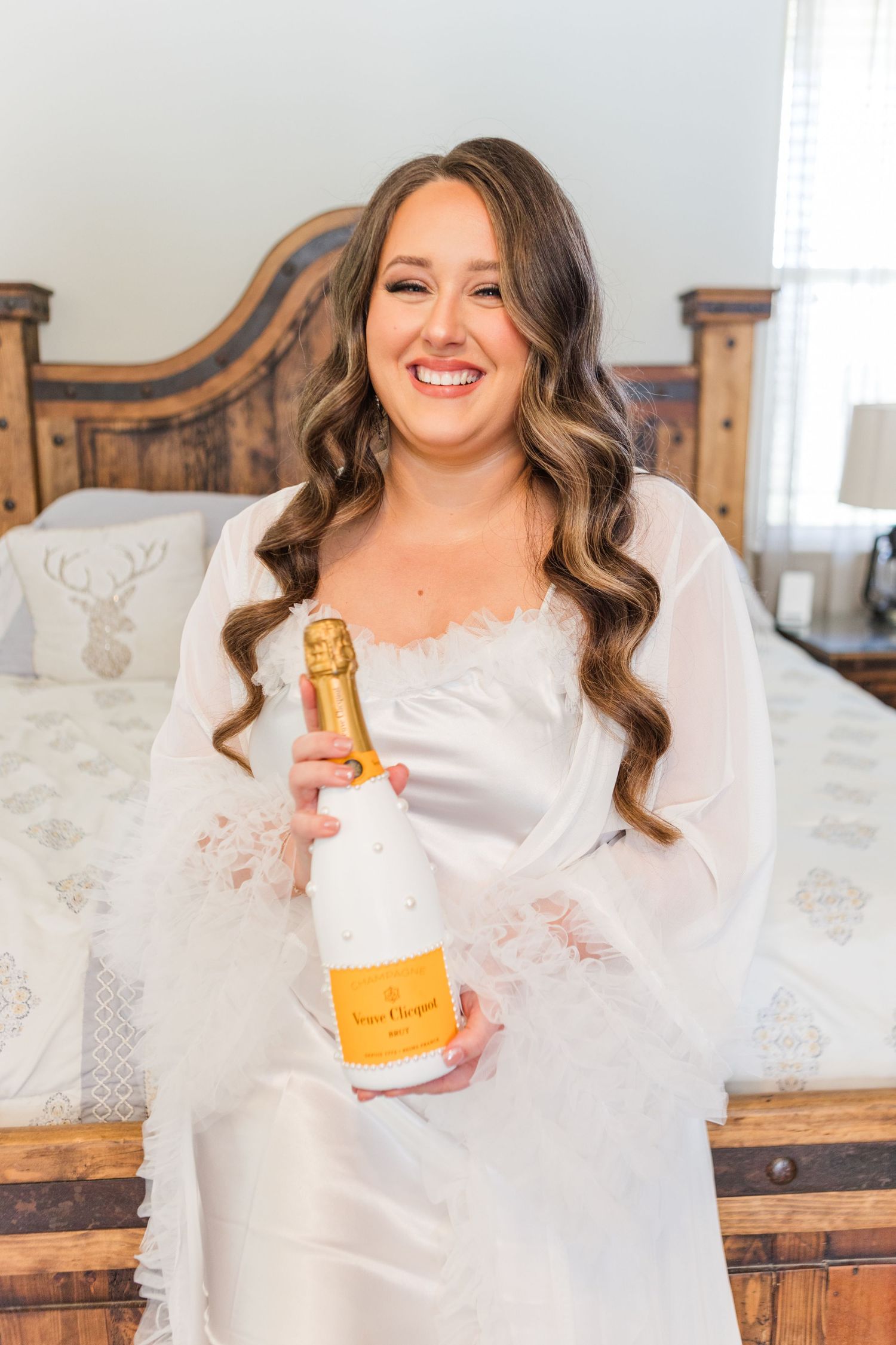 Celebratory moment with champagne bottle in white dress.