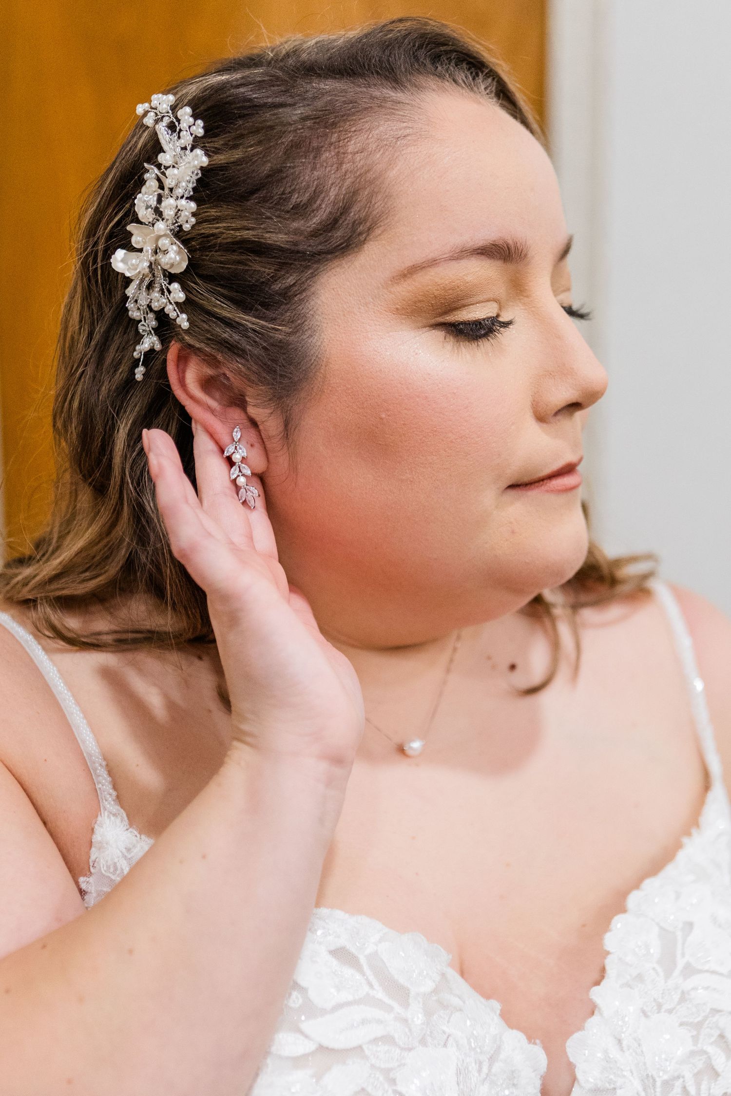 Bride wearing lace dress and crystal hair accessories in elegant poses.