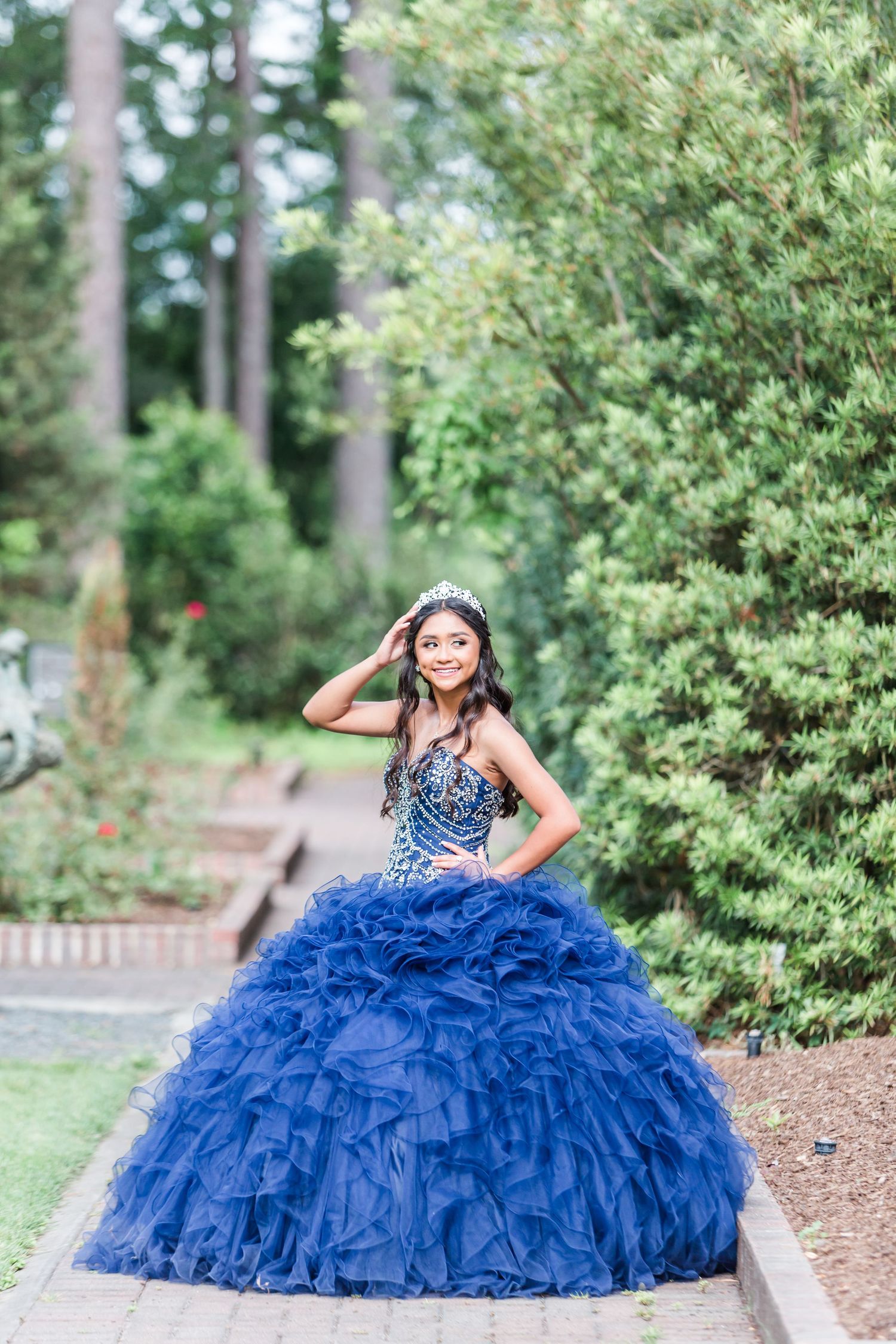 Dramatic royal blue ruffled ballgown captured in a garden photoshoot series.