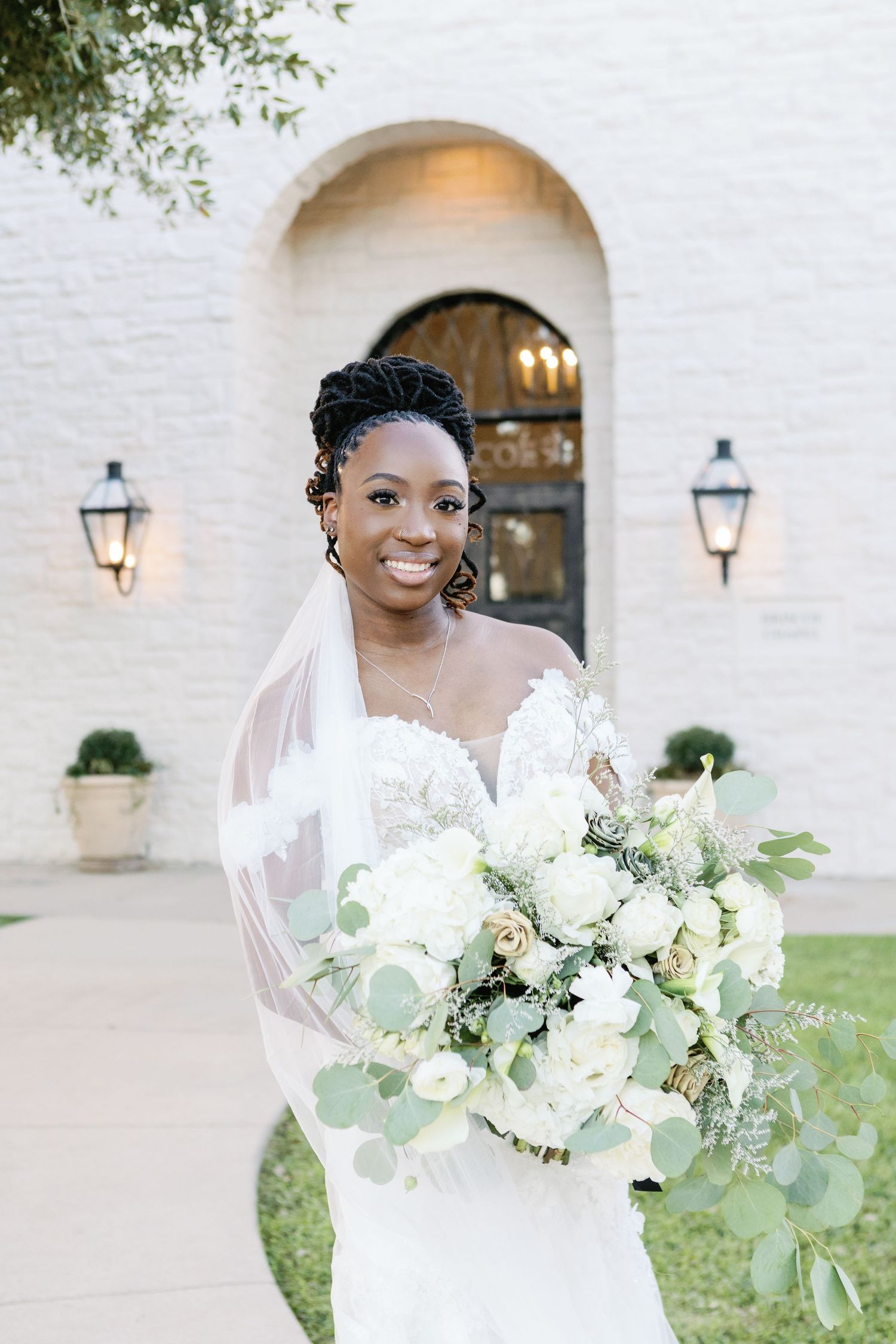 White bridal bouquet with lush greenery and classic flowers creates an elegant wedding day arrangement.
