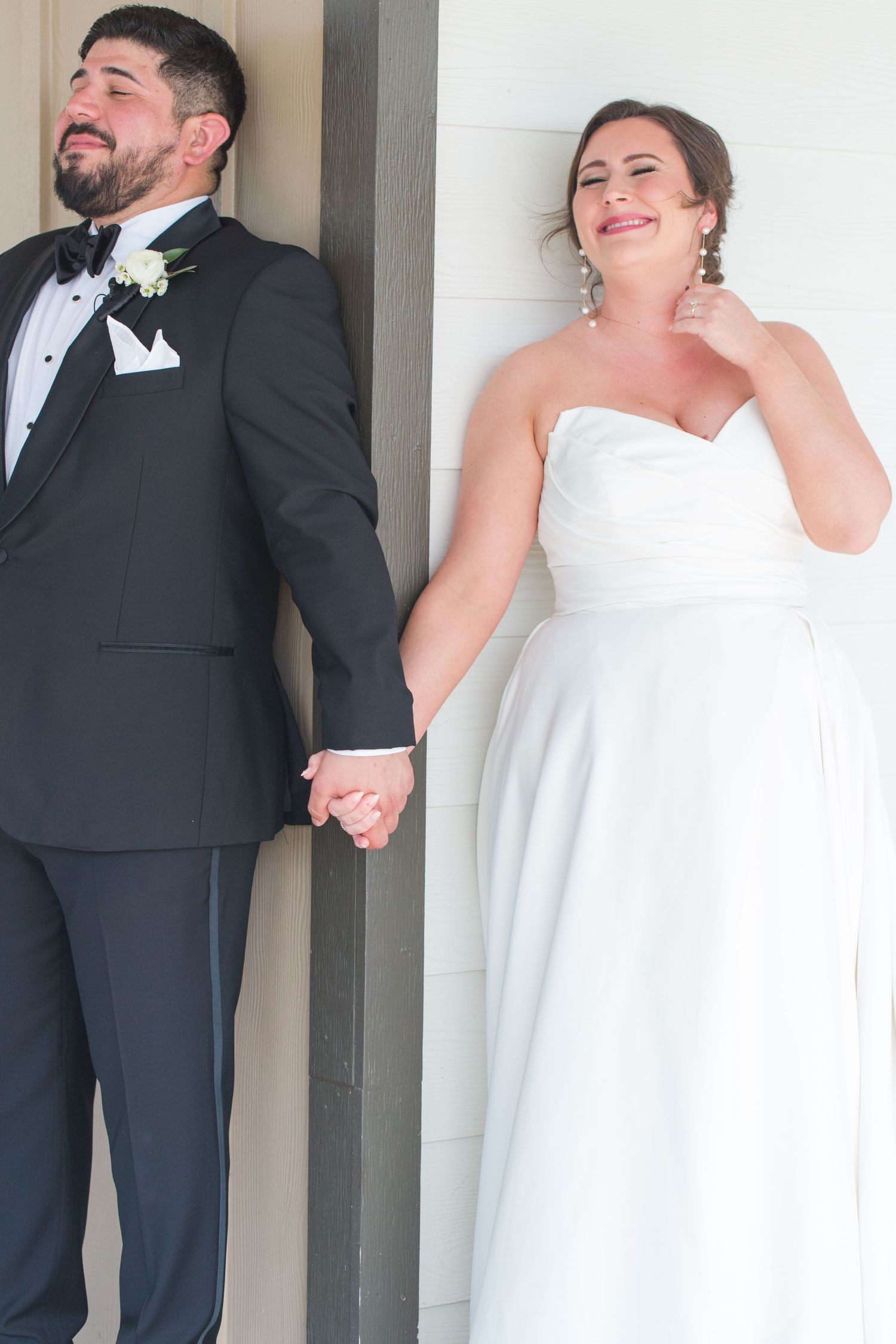 Bride and groom laugh joyfully during their first look photo session.
