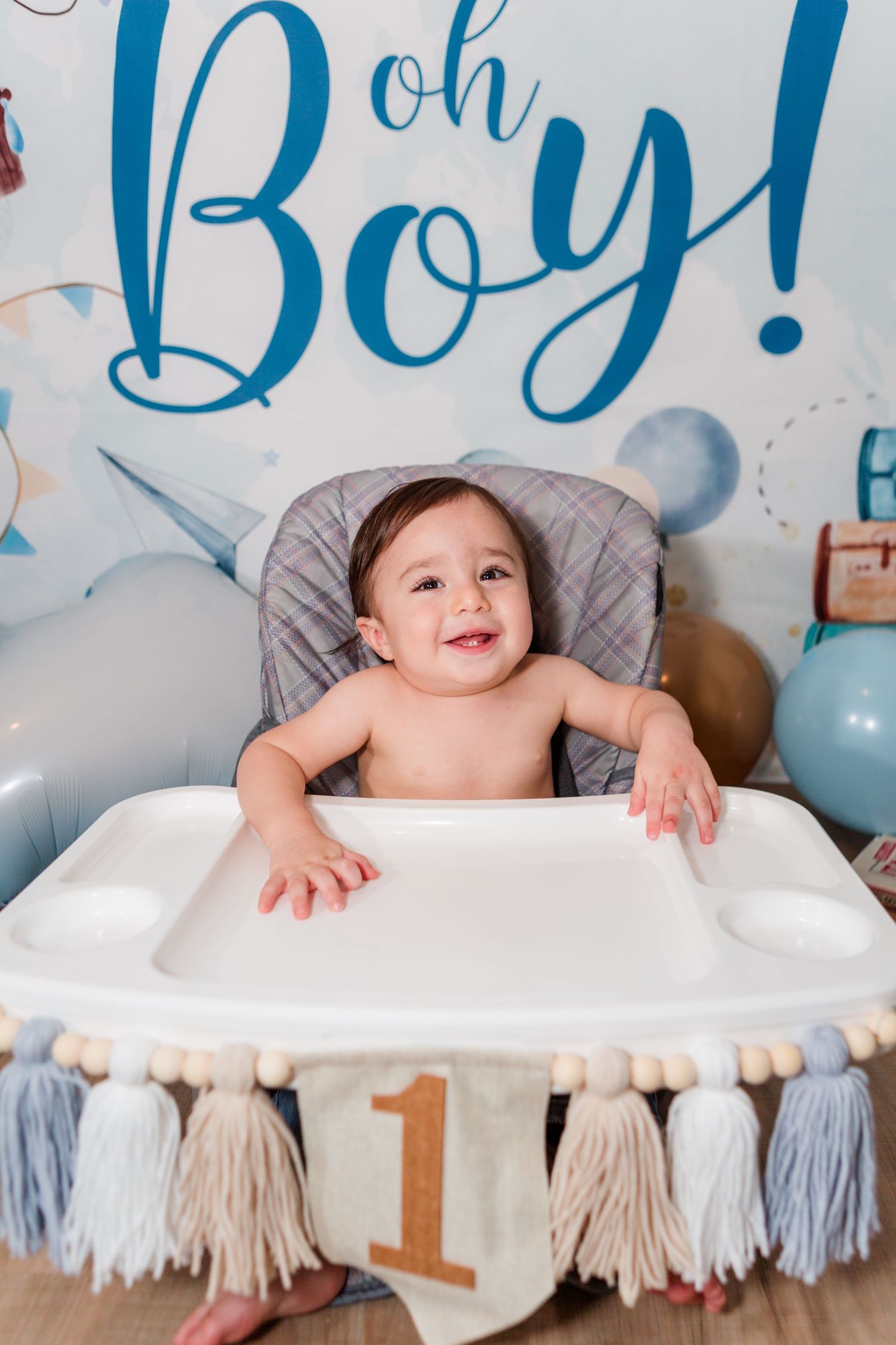 First birthday setup with blue lettering and tassel decorations.