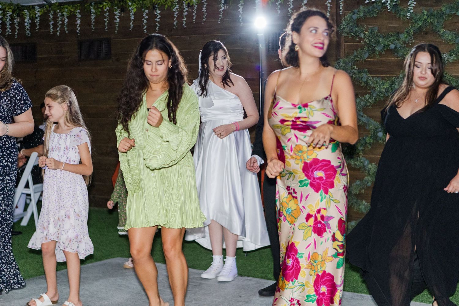 Wedding reception dance party with string lights and guests enjoying the celebration.