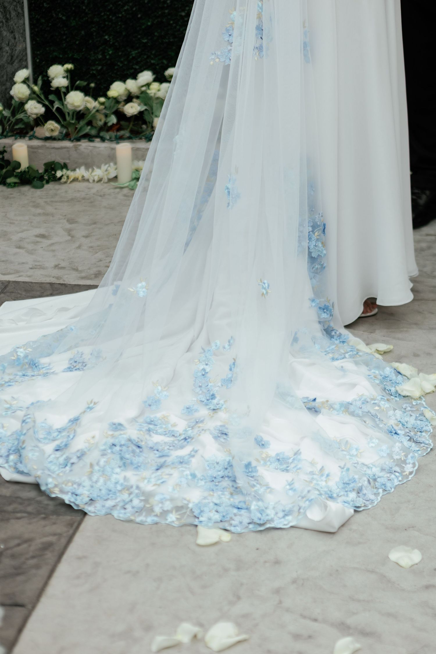 Wedding dress train features delicate blue butterfly details and lace embellishments.