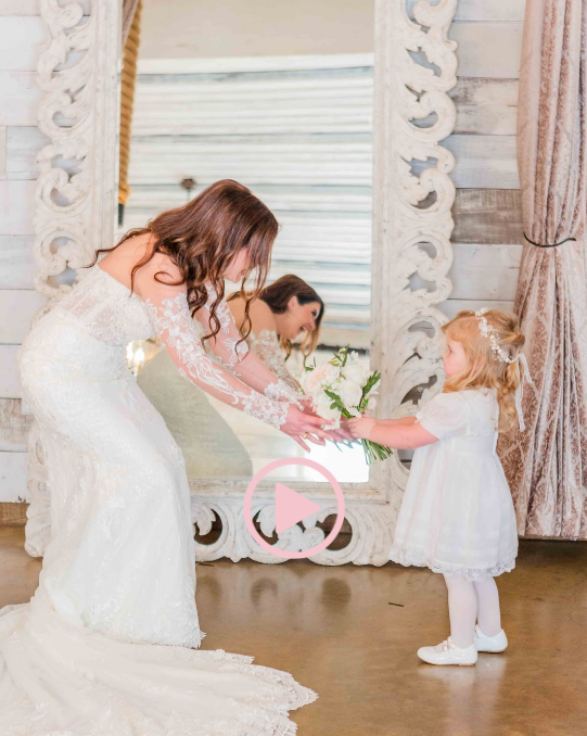 Playful wedding party scene in an elegant white indoor setting.