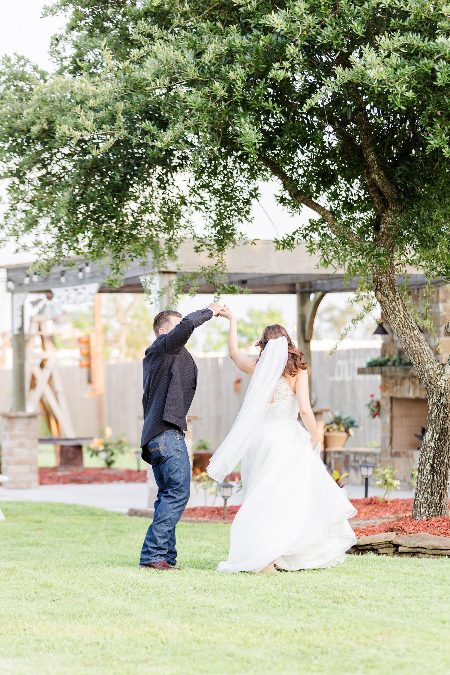 Dancing figures in flowing white dress and dark attire twirl in a sunlit garden.