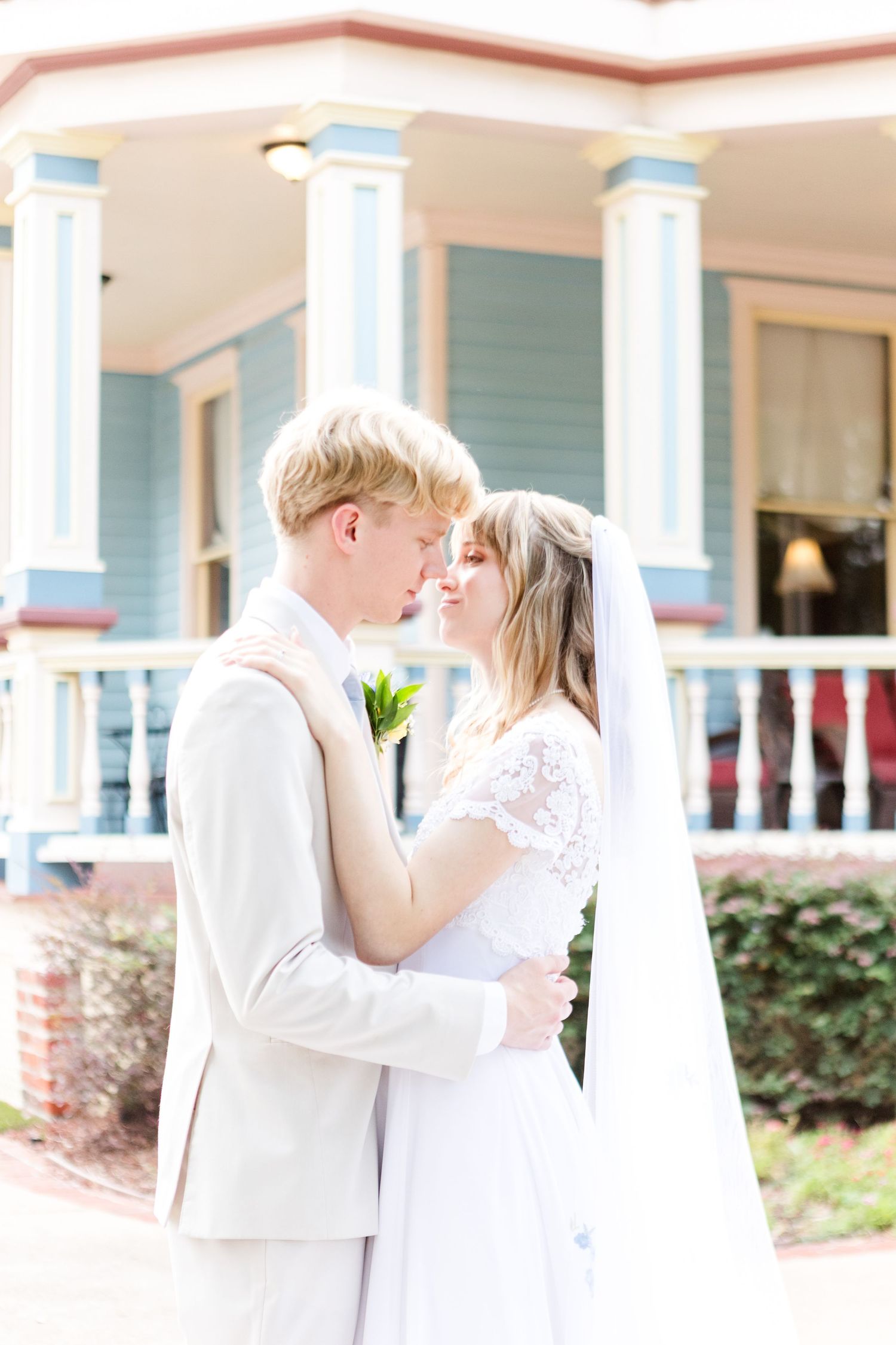 A romantic wedding photo series featuring a couple in white attire embracing on a porch with white columns.